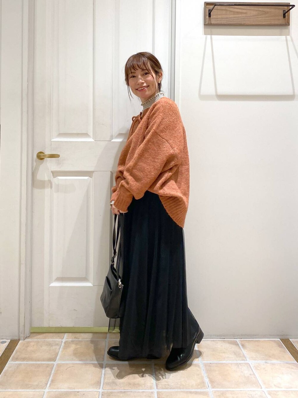 その他のTシャツ/カットソー、ブラック系のブーツ、オレンジ系のニット/セーターを着用したレディースの冬コーディネートの4枚目の写真