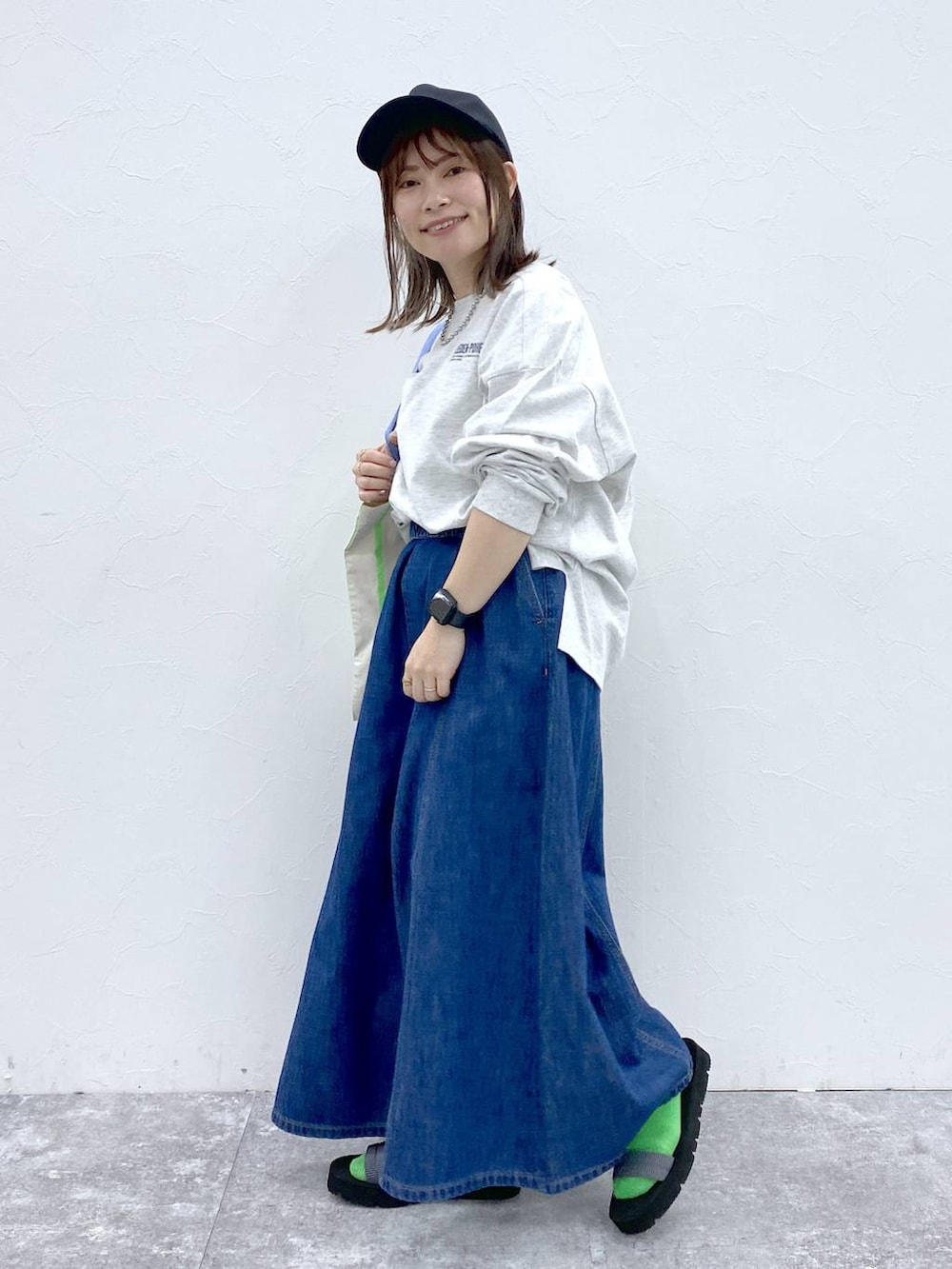 ブルー系のデニムパンツ、その他のトートバッグ、シルバー系のネックレスを着用したレディースの冬コーディネートの3枚目の写真