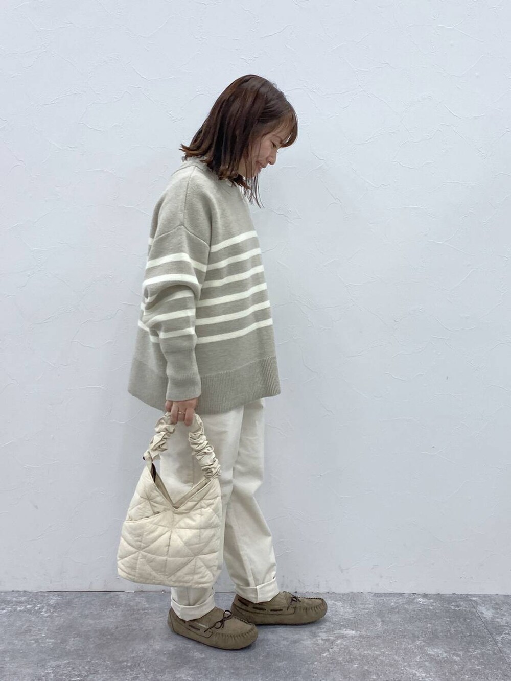 グレー系のTシャツ/カットソー、グレー系のモカシン/デッキシューズ、ベージュ系のトートバッグを着用したレディースの冬コーディネートの5枚目の写真