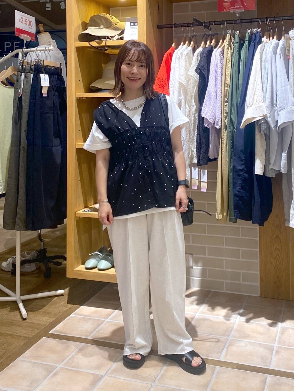 ブラック系のサンダル、ブラック系のその他パンツ、ホワイト系のTシャツ/カットソーを着用したレディースの夏コーディネートの2枚目の写真