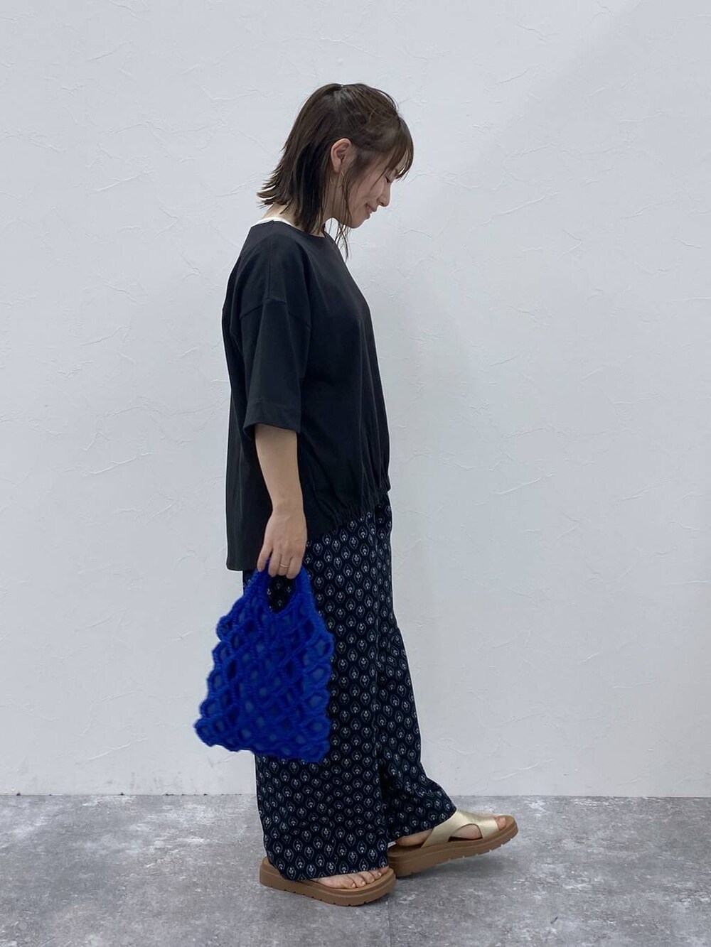 ゴールド系のサンダル、ブラック系のその他パンツ、ブラック系のTシャツ/カットソーを着用したレディースの夏コーディネートの5枚目の写真