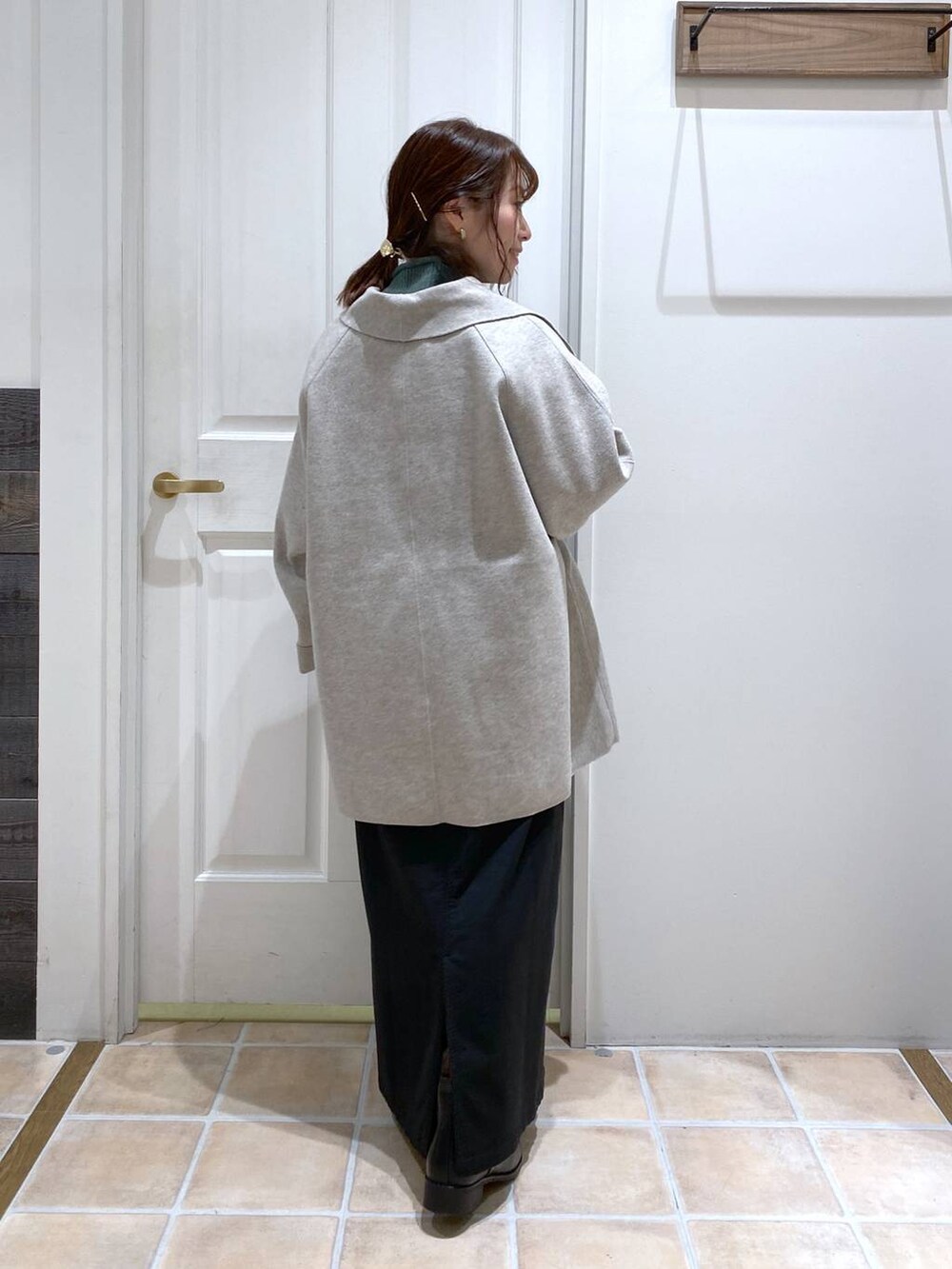 ブラック系のスカート、グレー系のテーラードジャケット、ブラック系のブーツを着用したレディースの秋コーディネートの5枚目の写真