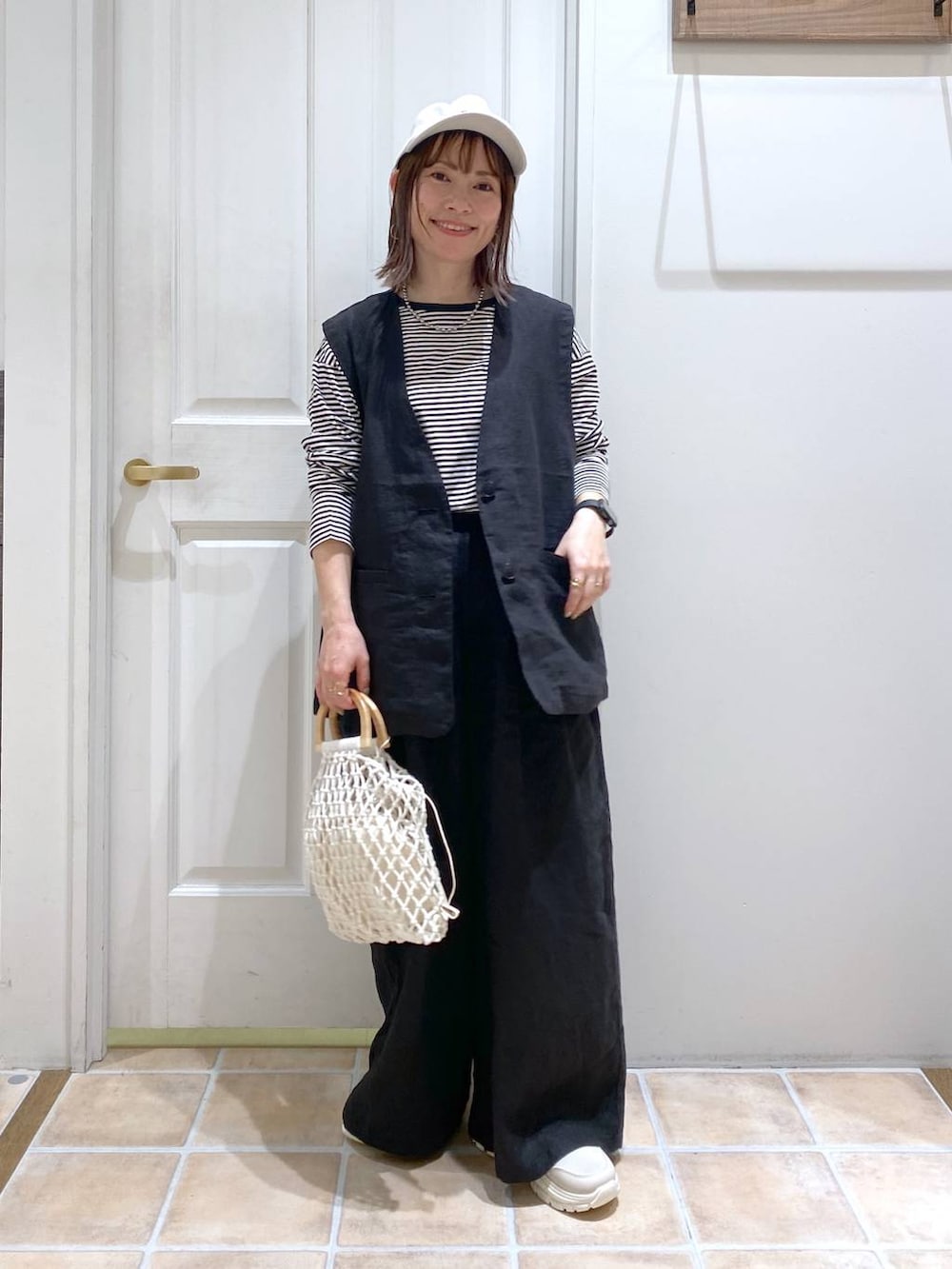 ベージュ系のスニーカー、ブラック系のその他パンツ、ブラック系のベストを着用したレディースの春コーディネートの4枚目の写真