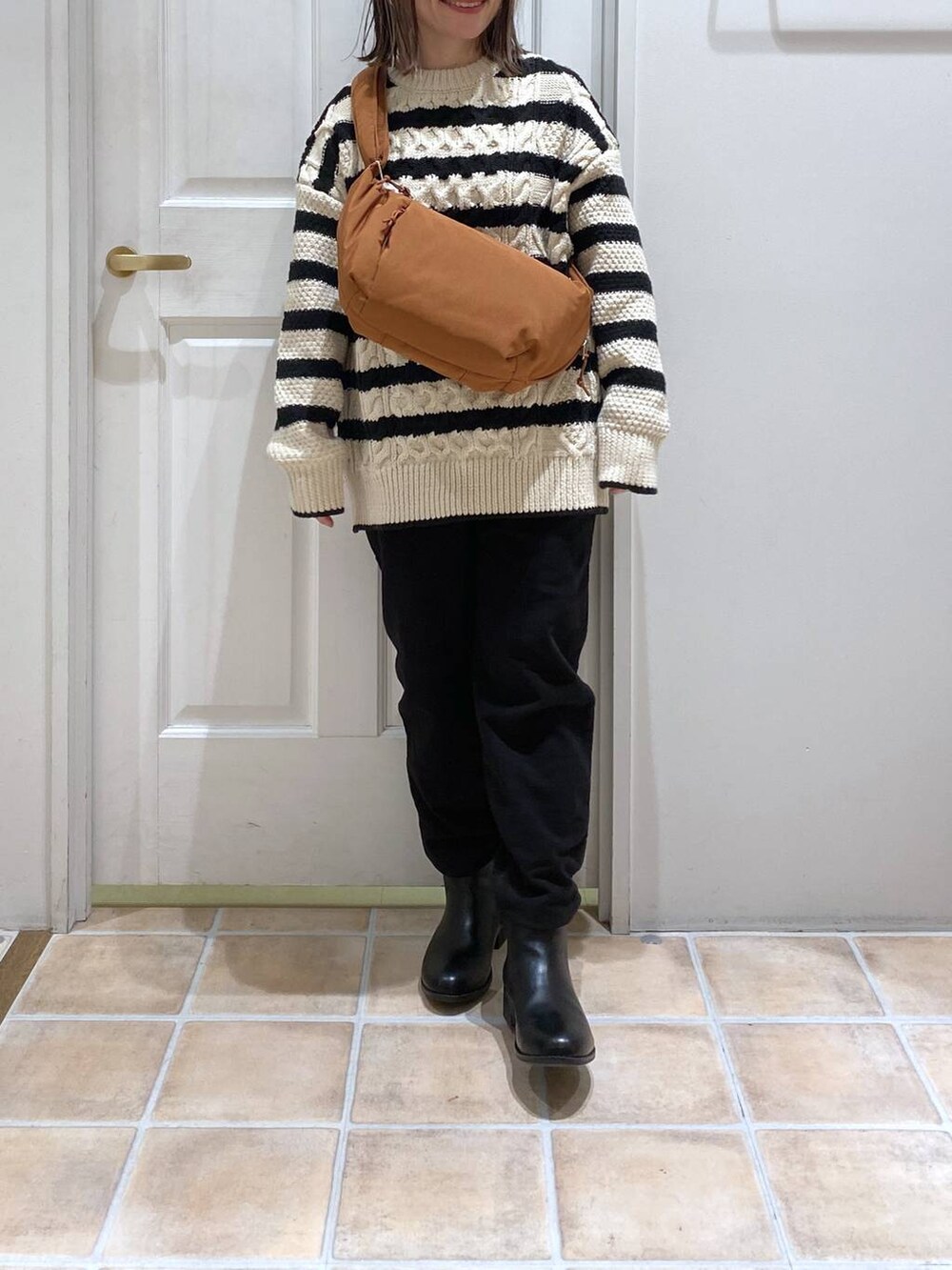 ブラック系のブーツ、その他のニット/セーター、ブラック系のその他パンツを着用したレディースの冬コーディネートの3枚目の写真