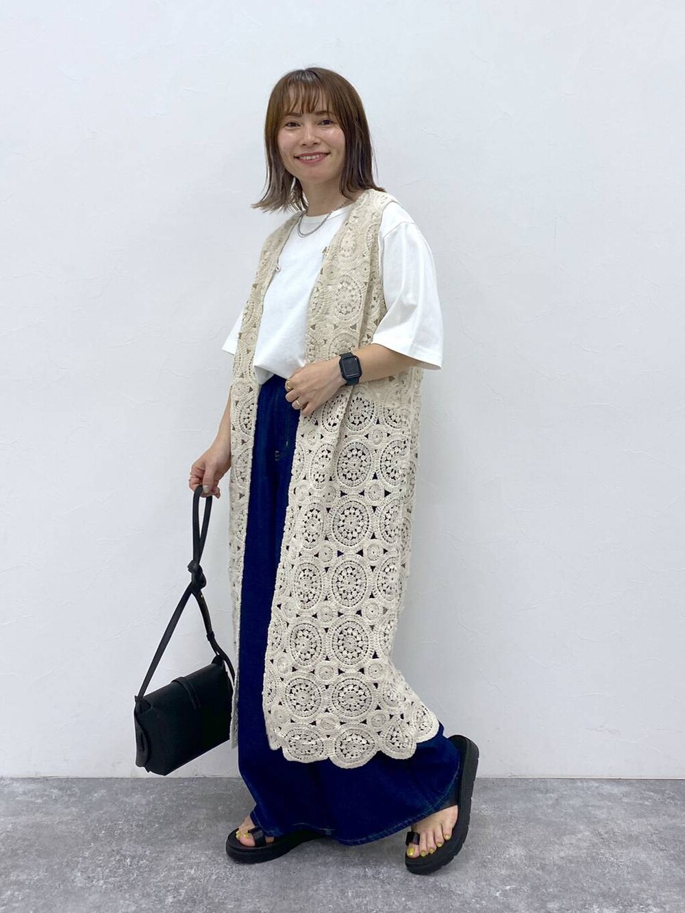 ブラック系のサンダル、ホワイト系のTシャツ/カットソー、ブラック系のショルダーバッグを着用したレディースの夏コーディネートの4枚目の写真