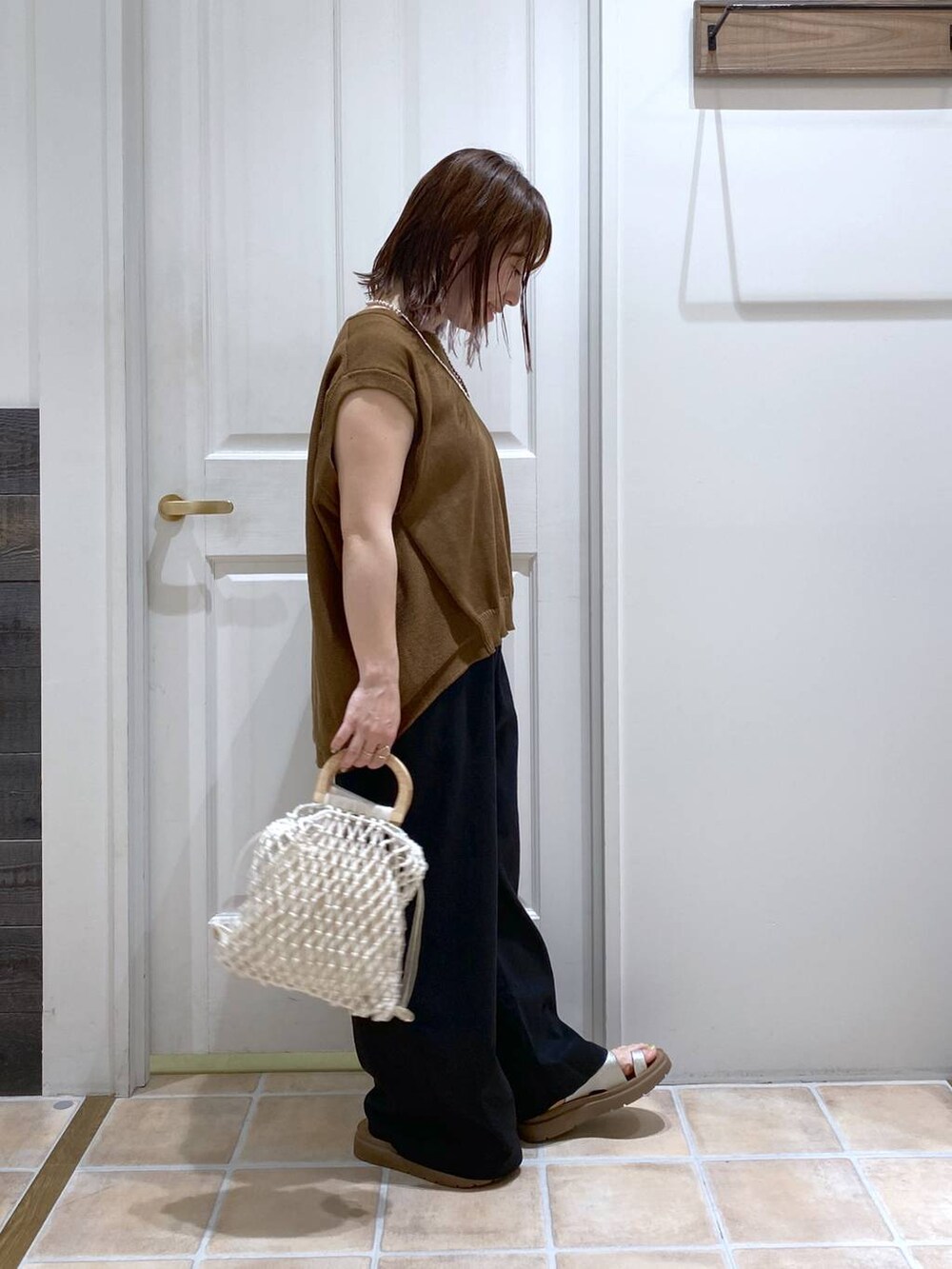 その他のサンダル、ブラック系のその他パンツ、ホワイト系のハンドバッグを着用したレディースの春コーディネートの5枚目の写真