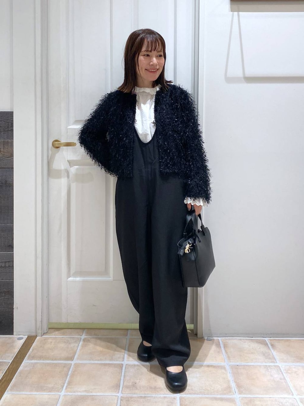 ブラック系のサロペット/オーバーオール、ブラック系のパンプス、ホワイト系のシャツ/ブラウスを着用したレディースの秋コーディネートの5枚目の写真