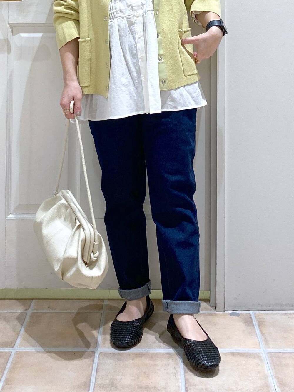 ホワイト系のショルダーバッグ、ブルー系のデニムパンツ、ホワイト系のビジネスシャツを着用したレディースの春コーディネートの4枚目の写真