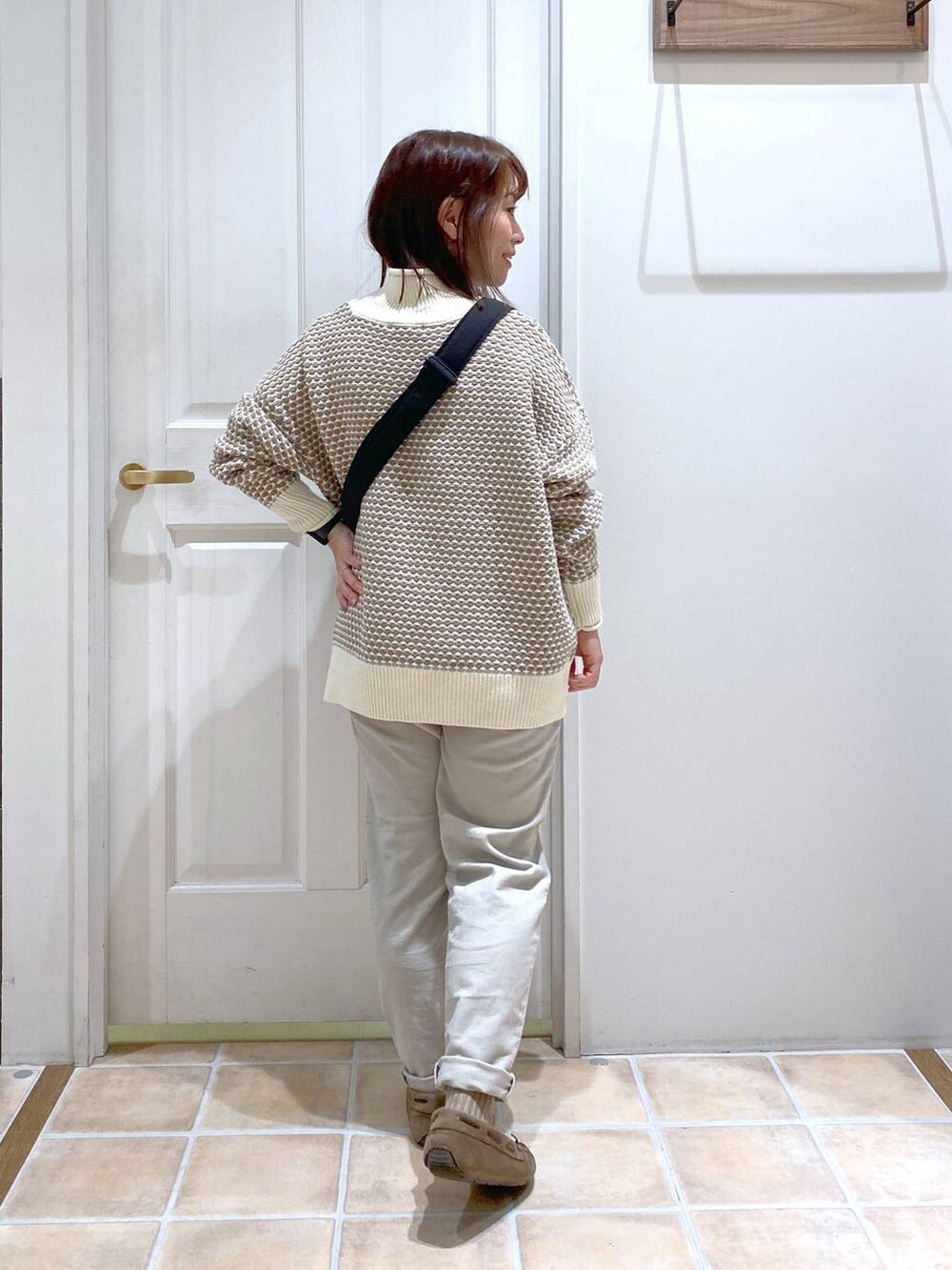 グレー系のその他パンツ、ホワイト系のニット/セーター、グレー系のモカシン/デッキシューズを着用したレディースの秋コーディネートの5枚目の写真