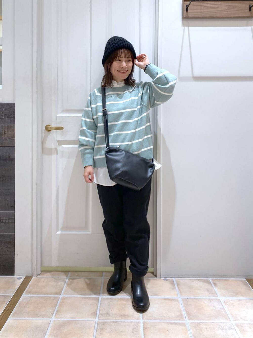 ブラック系のブーツ、グリーン系のニット/セーター、ブラック系のその他パンツを着用したレディースの冬コーディネートの2枚目の写真