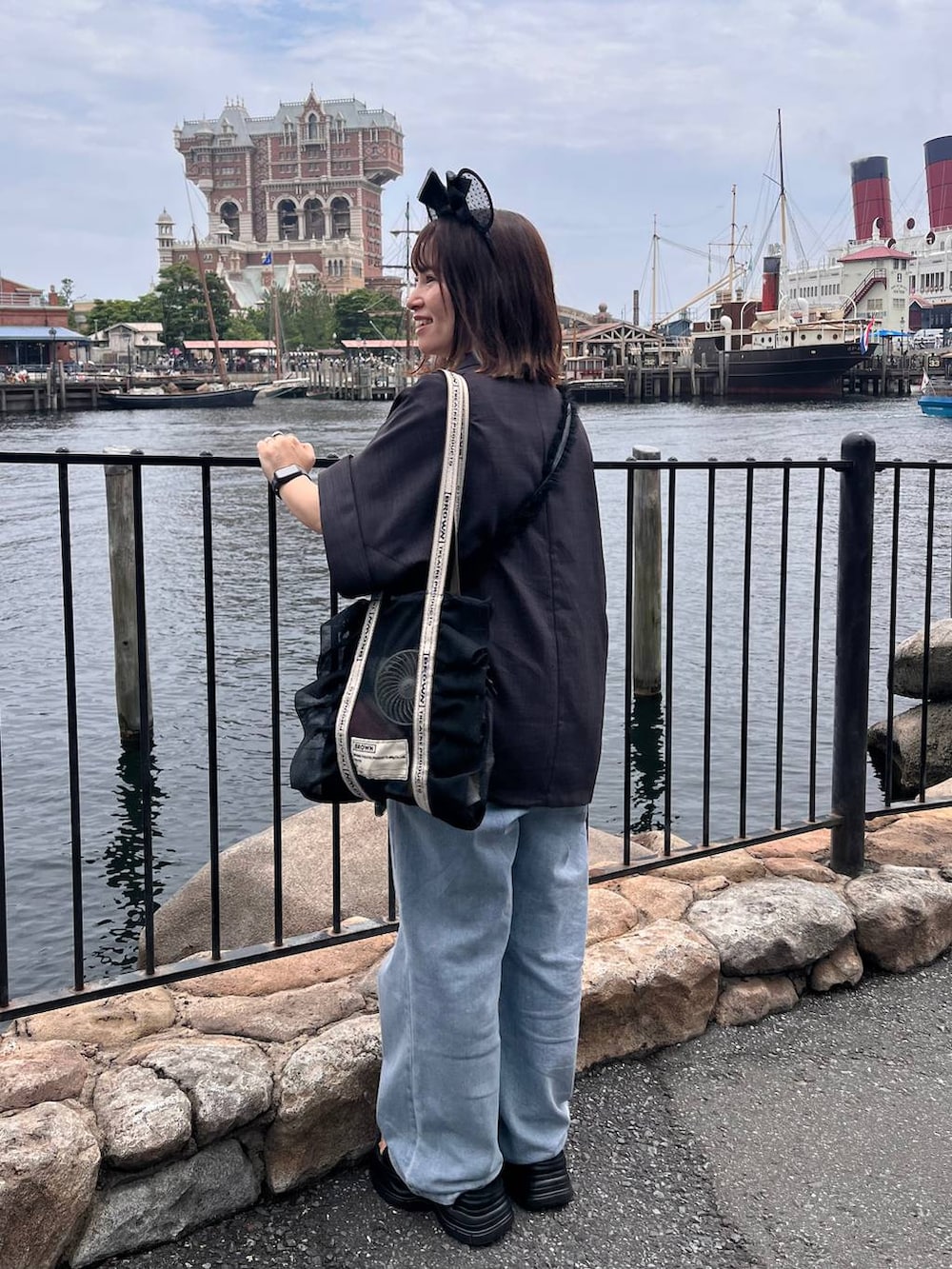 ブラック系のサンダル、ブルー系のデニムパンツ、グレー系のテーラードジャケットを着用したレディースの夏コーディネートの4枚目の写真