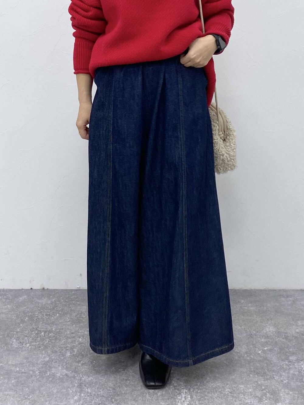 ブルー系のデニムパンツ、ブラック系のブーツを着用したレディースの秋コーディネートの3枚目の写真