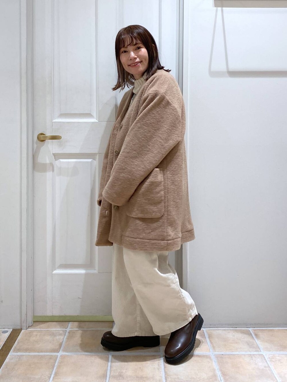 ホワイト系のその他パンツ、ブラウン系のノーカラージャケット、ブラウン系のブーツを着用したレディースの春コーディネートの4枚目の写真