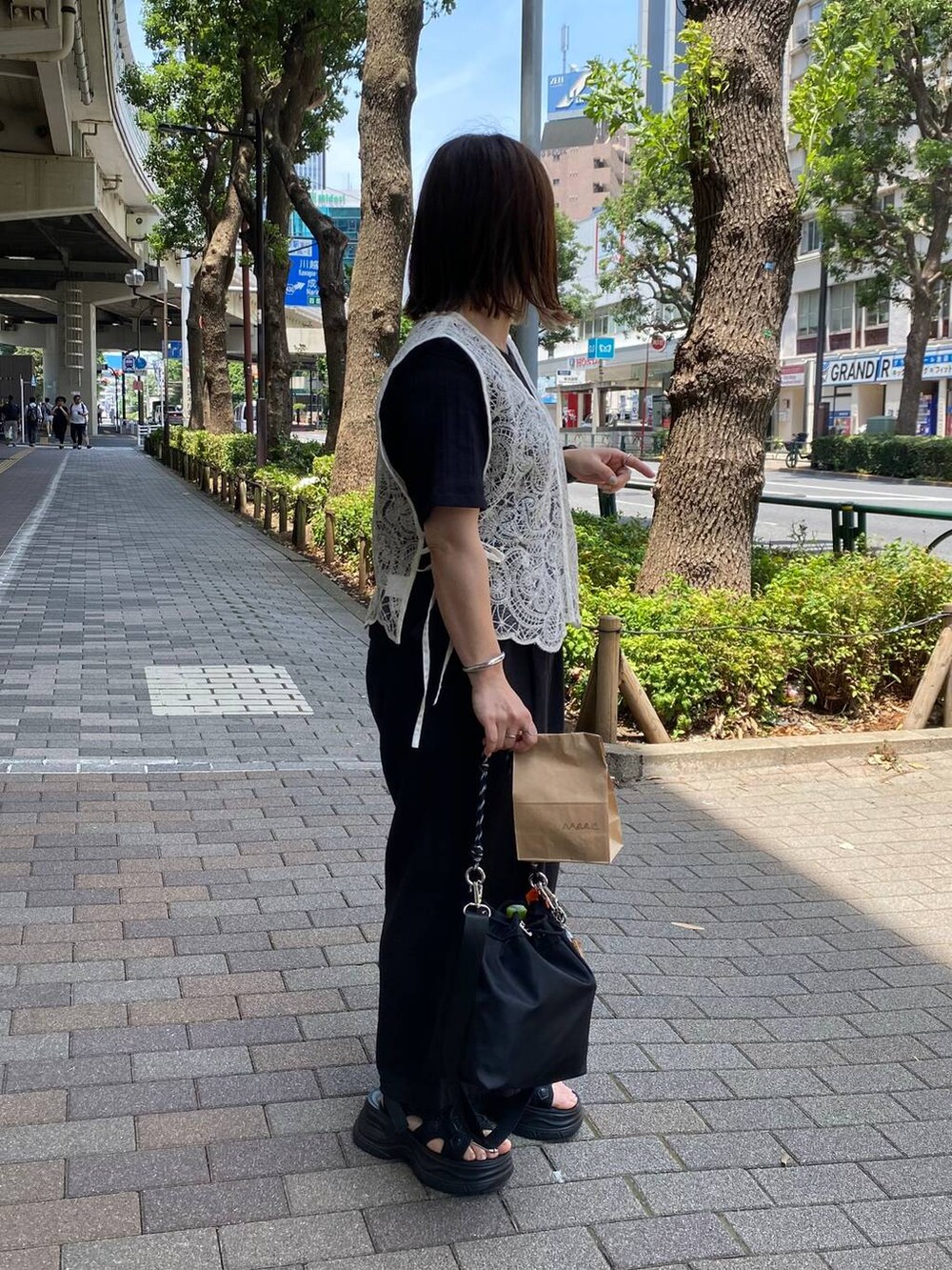 ブラック系のサンダル、ブラック系のTシャツ/カットソー、ブラック系のショルダーバッグを着用したレディースの夏コーディネートの2枚目の写真