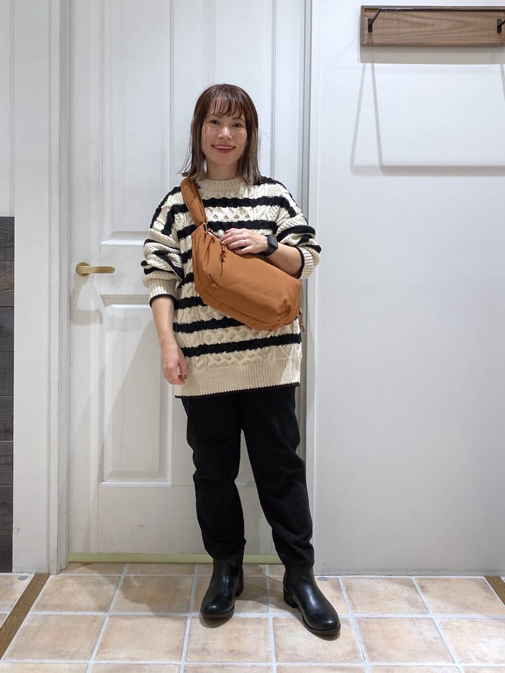 ブラック系のブーツ、その他のニット/セーター、ブラック系のその他パンツを着用したレディースの冬コーディネートの4枚目の写真