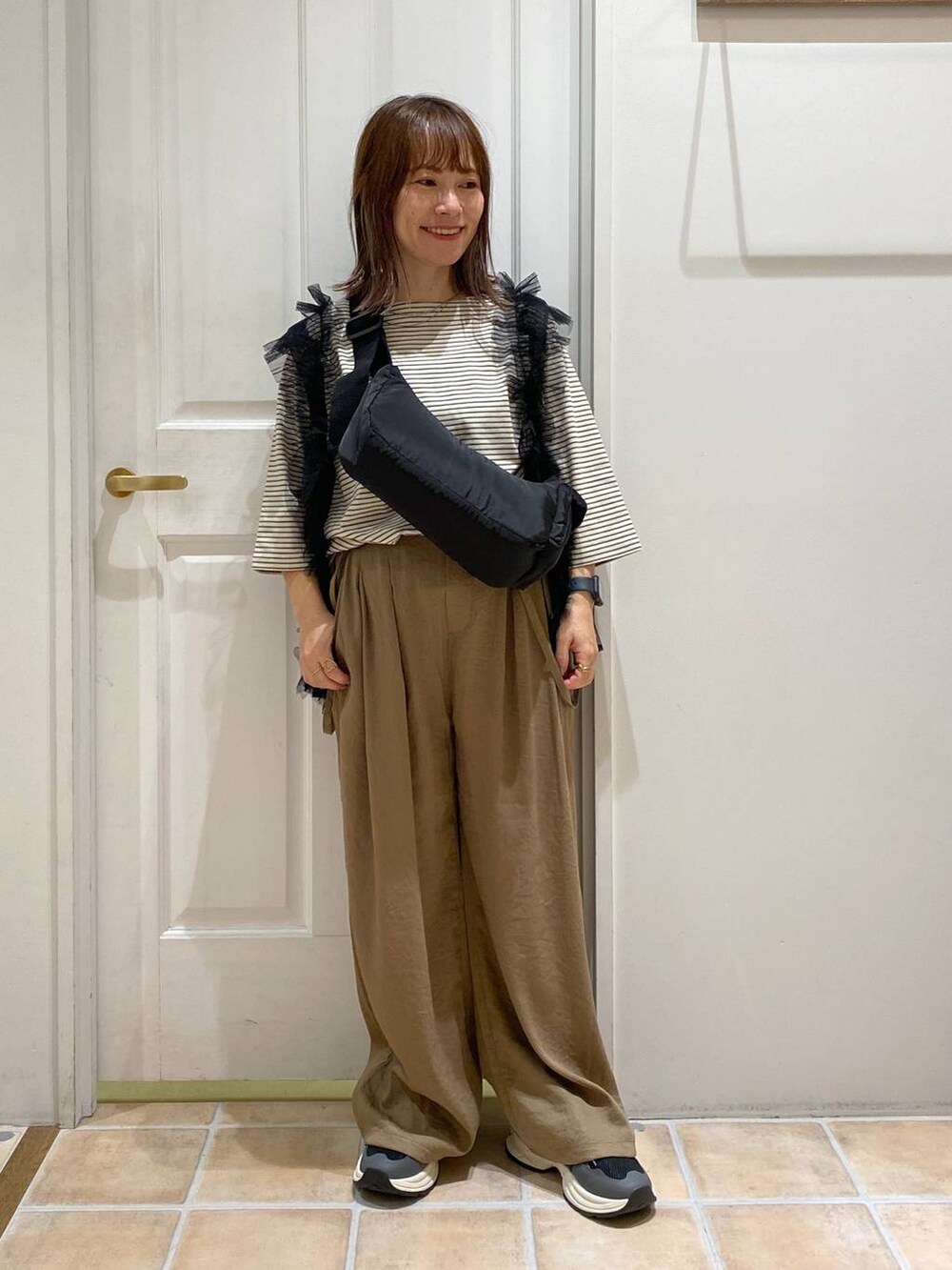 その他のTシャツ/カットソー、ブラック系のショルダーバッグ、ブラック系のスニーカーを着用したレディースの秋コーディネートの2枚目の写真