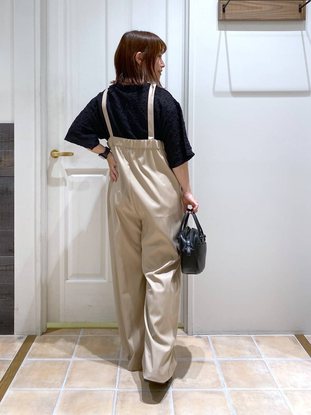 ブラック系のショルダーバッグ、ブラック系のサンダル、ブラック系のTシャツ/カットソーを着用したレディースの秋コーディネートの6枚目の写真