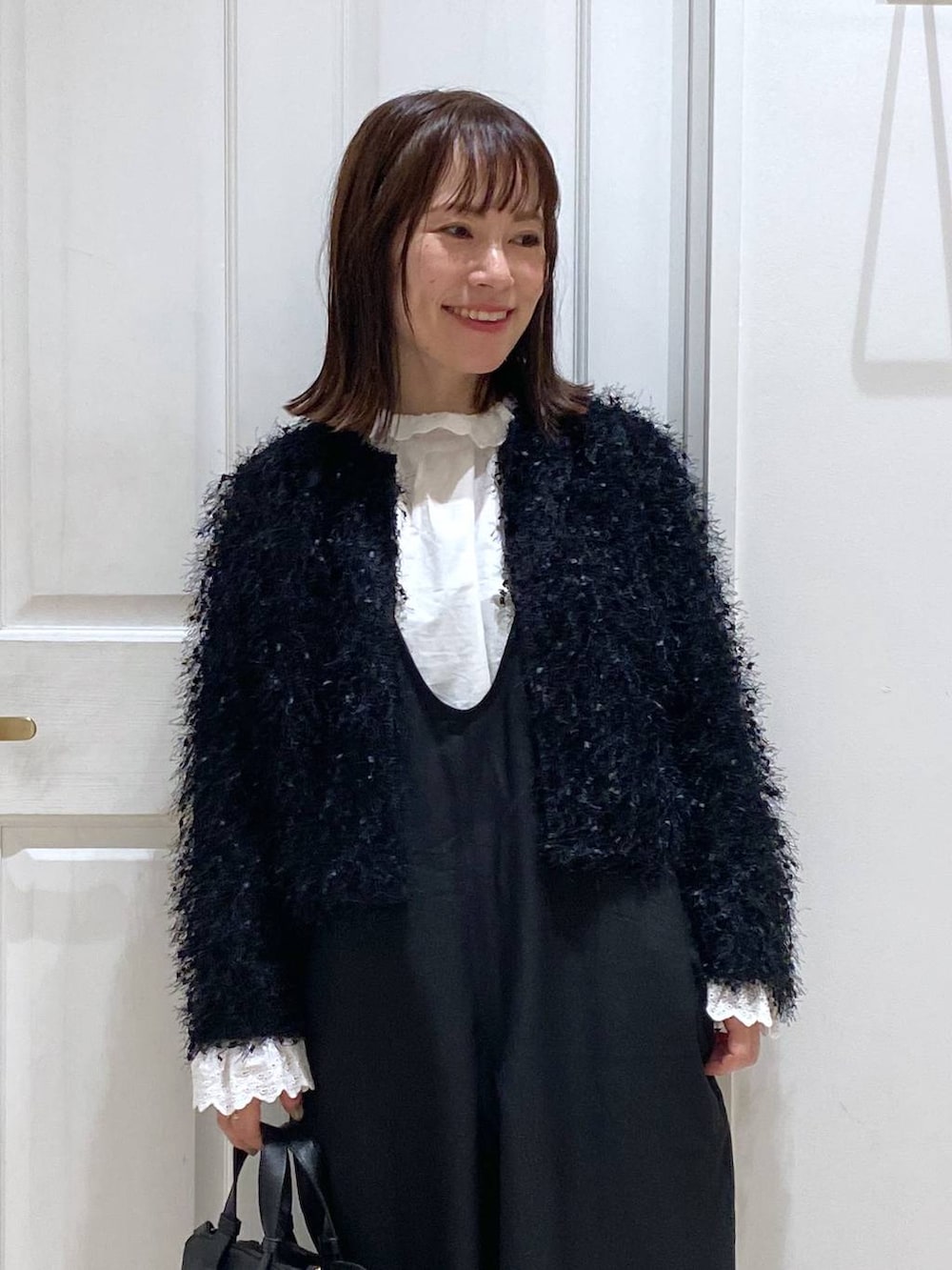 ブラック系のサロペット/オーバーオール、ブラック系のパンプス、ホワイト系のシャツ/ブラウスを着用したレディースの秋コーディネートの3枚目の写真