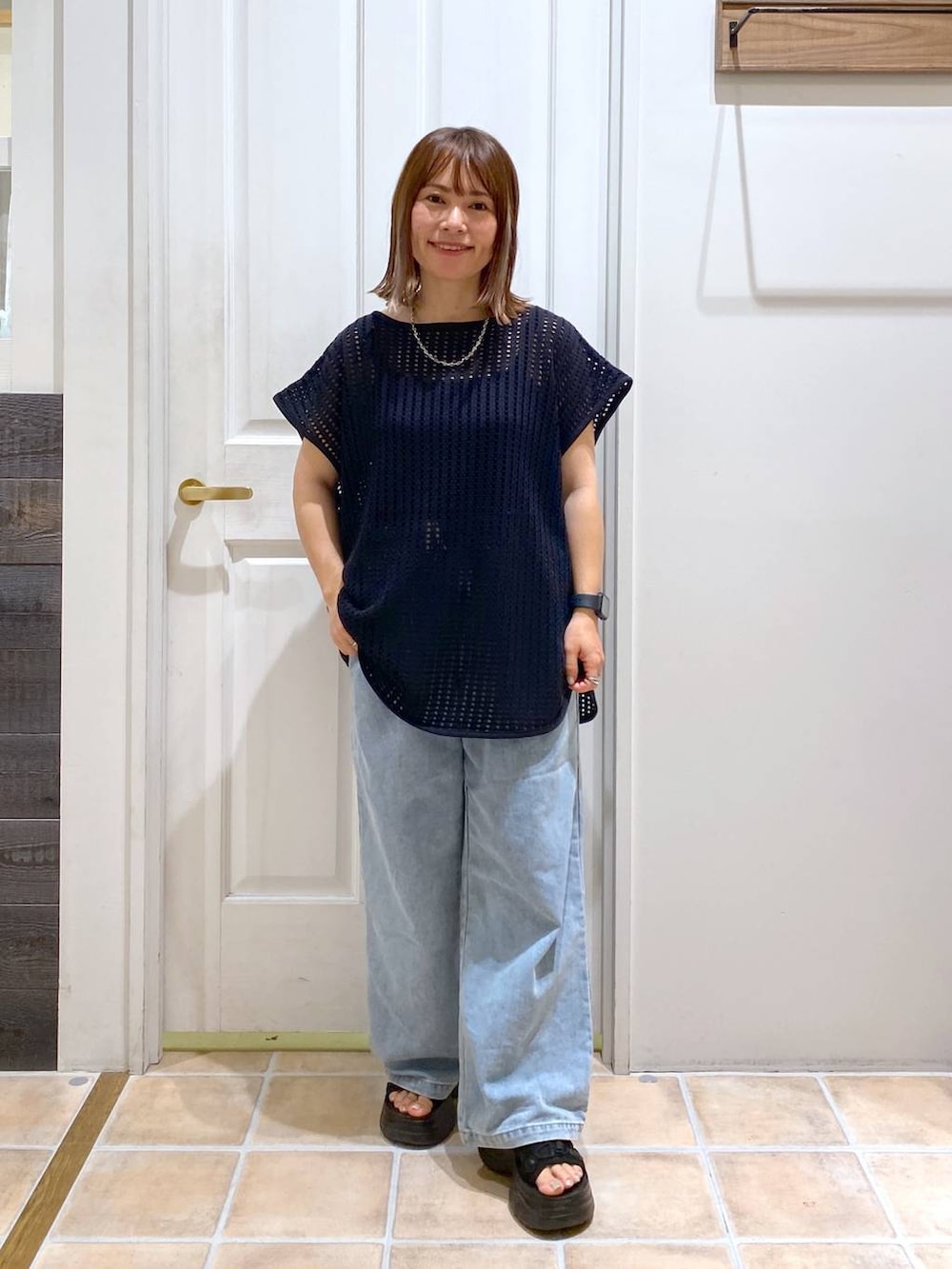 ブラック系のサンダル、ブルー系のデニムパンツ、ブラック系のTシャツ/カットソーを着用したレディースの夏コーディネートの3枚目の写真