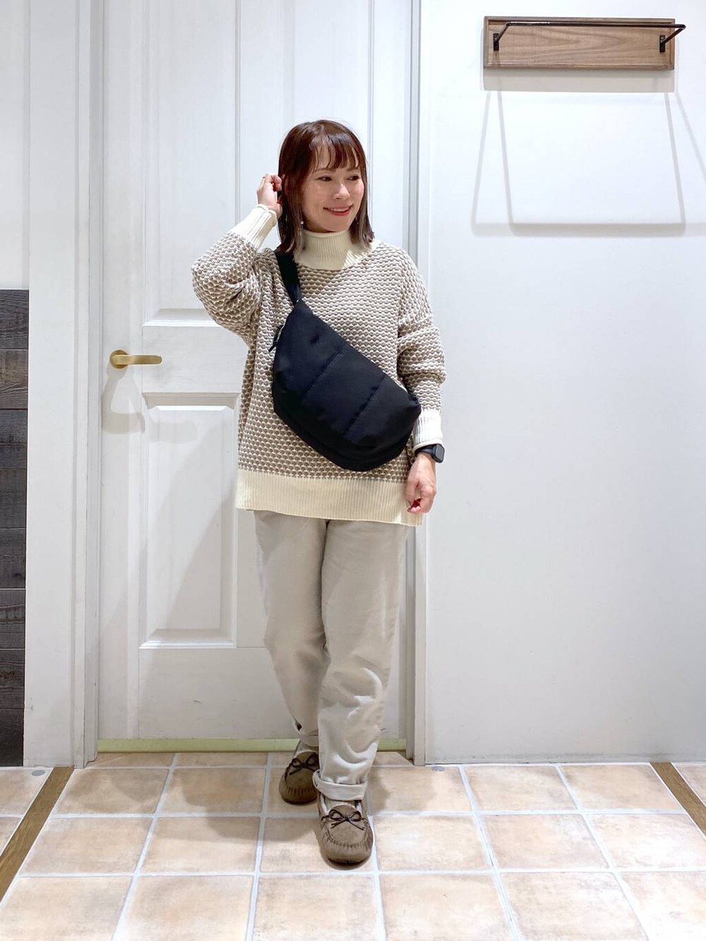 グレー系のその他パンツ、ホワイト系のニット/セーター、グレー系のモカシン/デッキシューズを着用したレディースの秋コーディネートの2枚目の写真