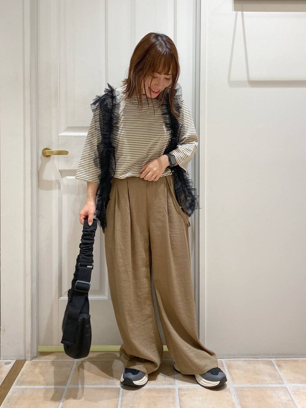 その他のTシャツ/カットソー、ブラック系のショルダーバッグ、ブラック系のスニーカーを着用したレディースの秋コーディネートの3枚目の写真