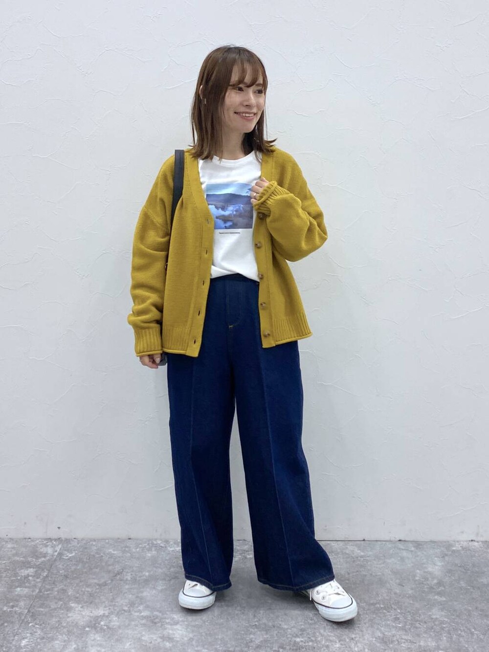 ブルー系のデニムパンツ、イエロー系のカーディガン/ボレロ、その他のTシャツ/カットソーを着用したレディースの秋コーディネートの2枚目の写真