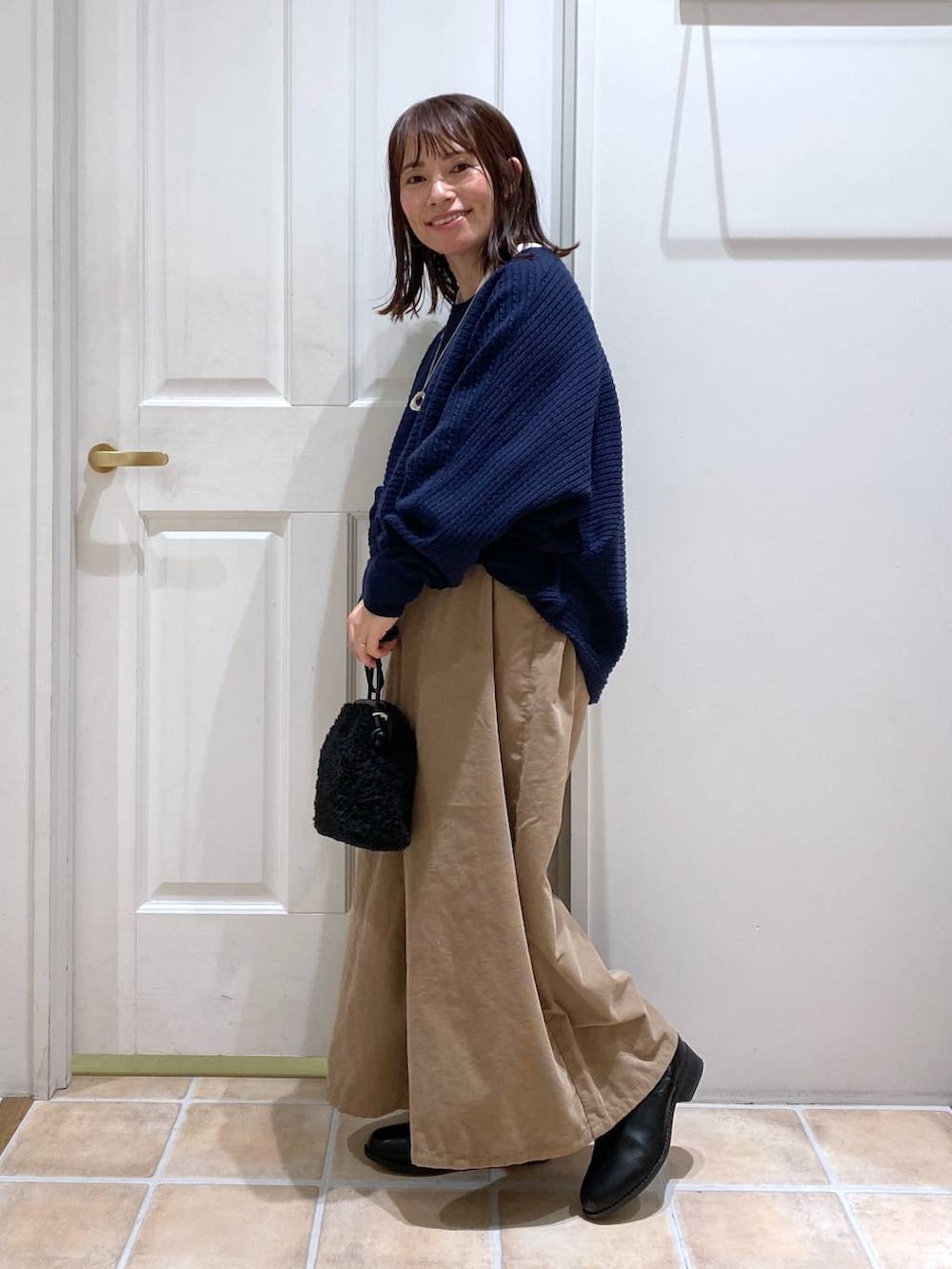 ベージュ系のその他パンツ、ブラック系のブーツ、ブルー系のニット/セーターを着用したレディースの秋コーディネートの5枚目の写真