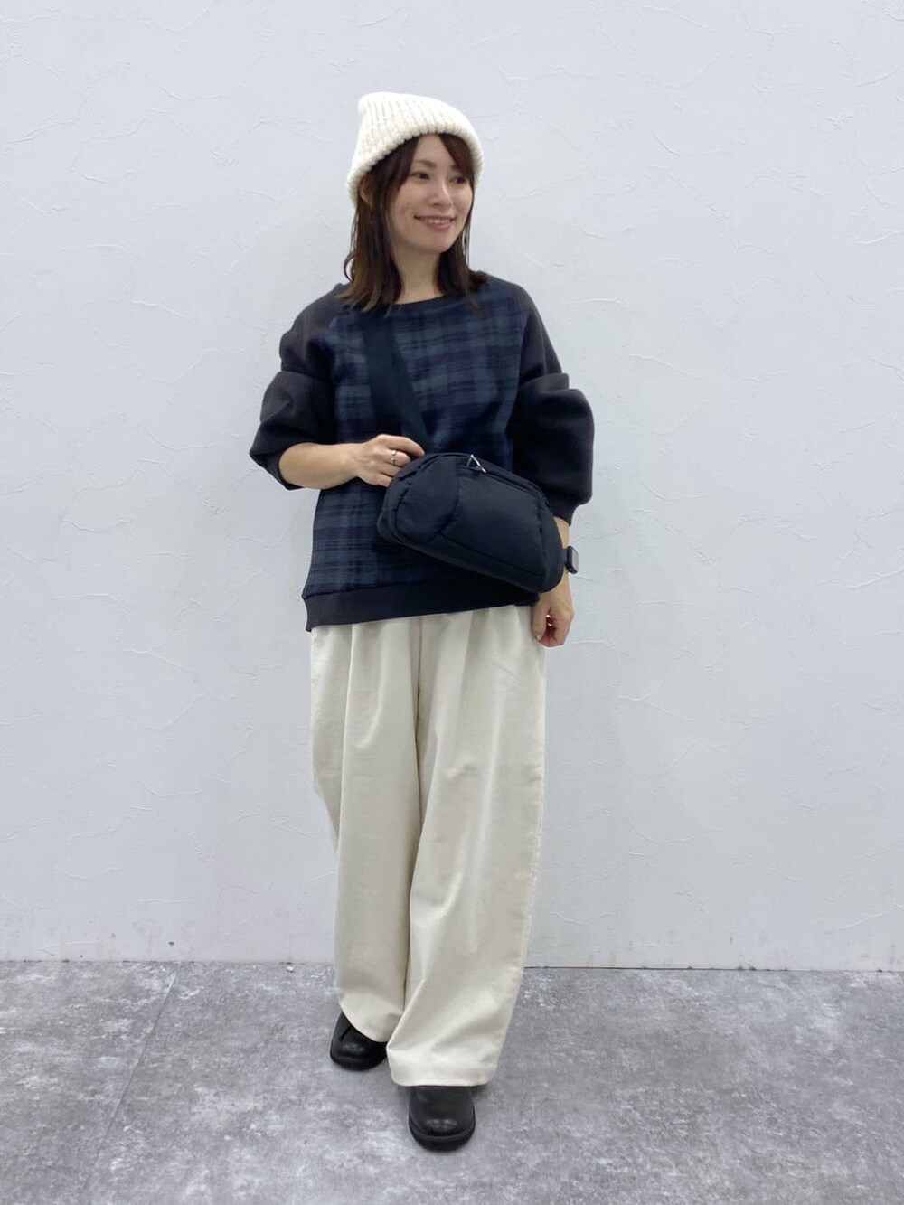 ベージュ系のその他パンツ、ブラック系のドレスシューズ、ブラック系のショルダーバッグを着用したレディースの秋コーディネートの2枚目の写真