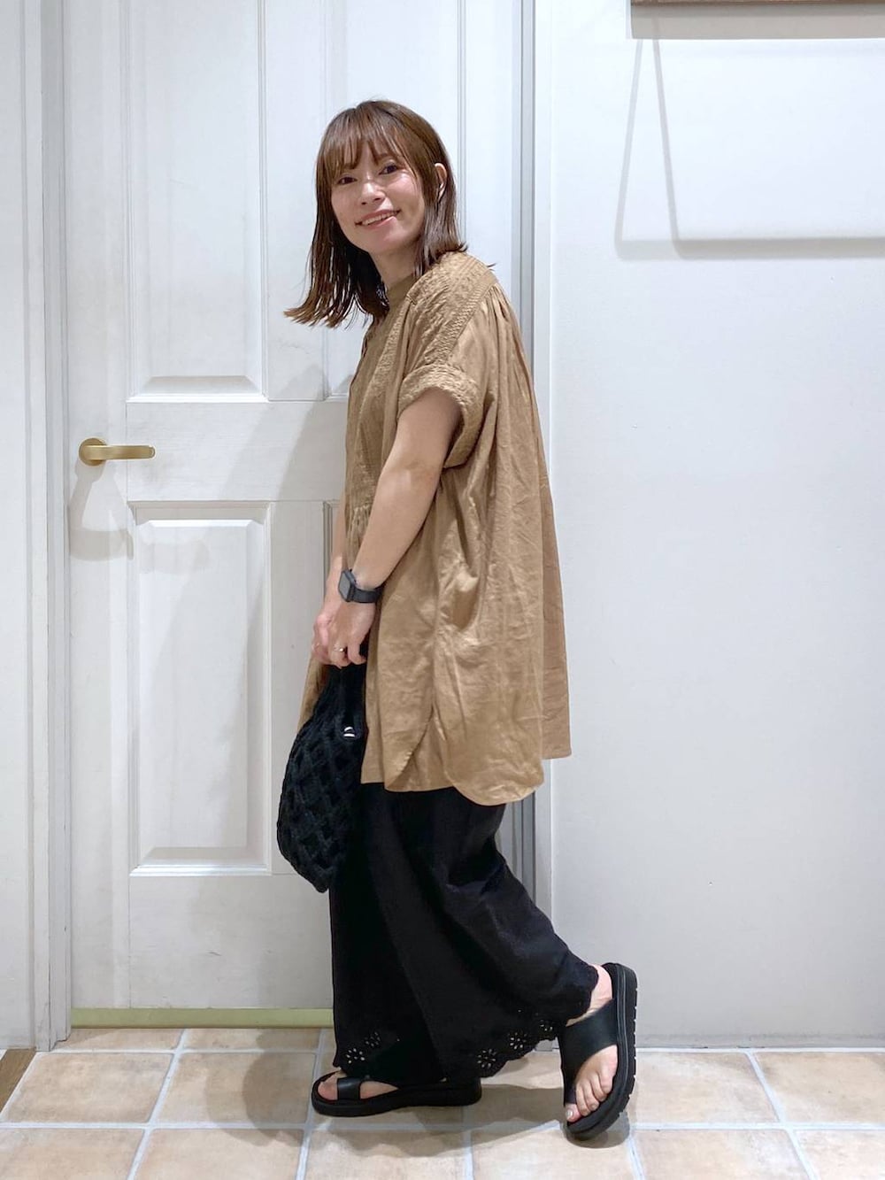 ブラウン系のタンクトップ、ブラック系のその他パンツ、ブラック系のサンダルを着用したレディースの夏コーディネートの4枚目の写真