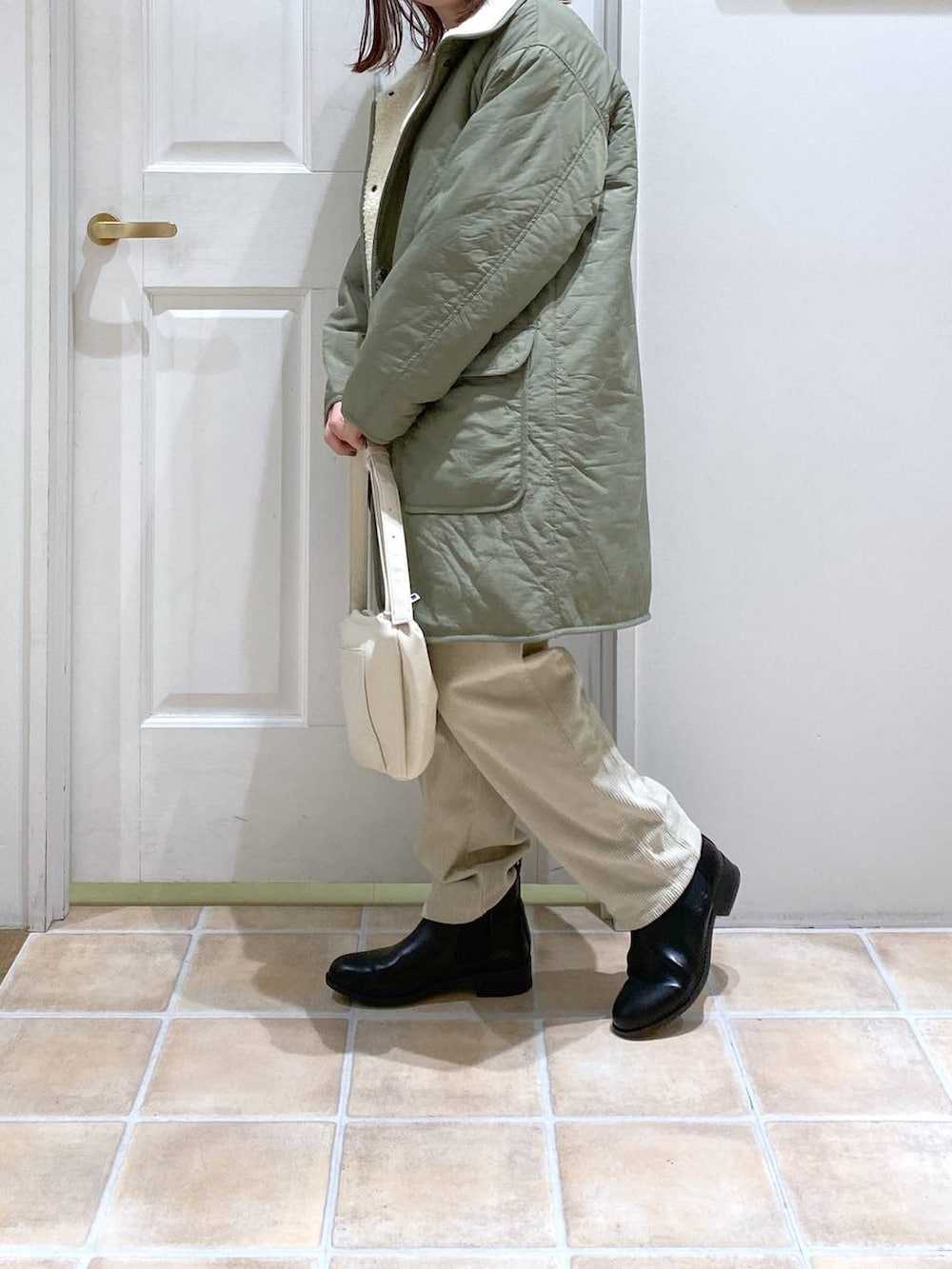 グリーン系のその他アウター、ブラック系のブーツ、グレー系のその他パンツを着用したレディースの冬コーディネートの4枚目の写真