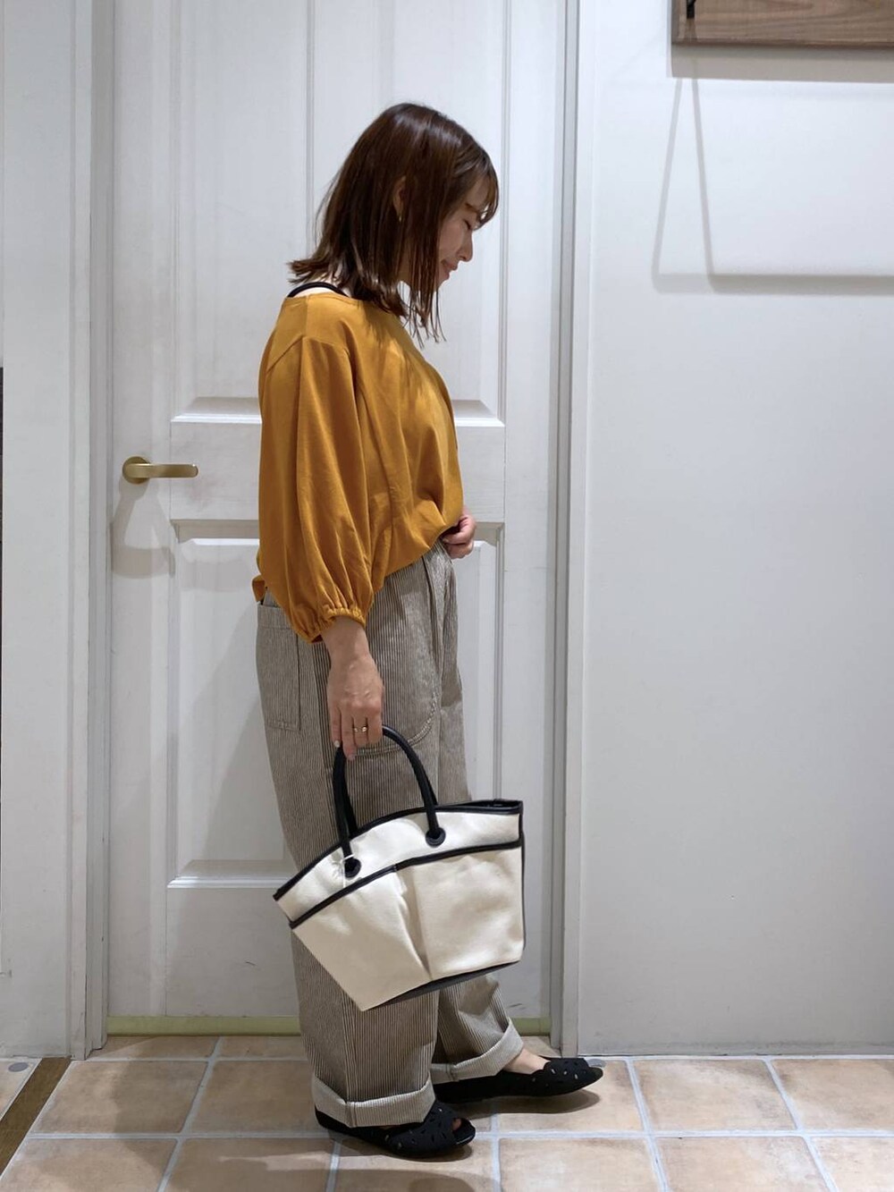 オレンジ系のTシャツ/カットソー、ブラック系のキャミソール、その他のデニムパンツを着用したレディースの夏コーディネートの6枚目の写真