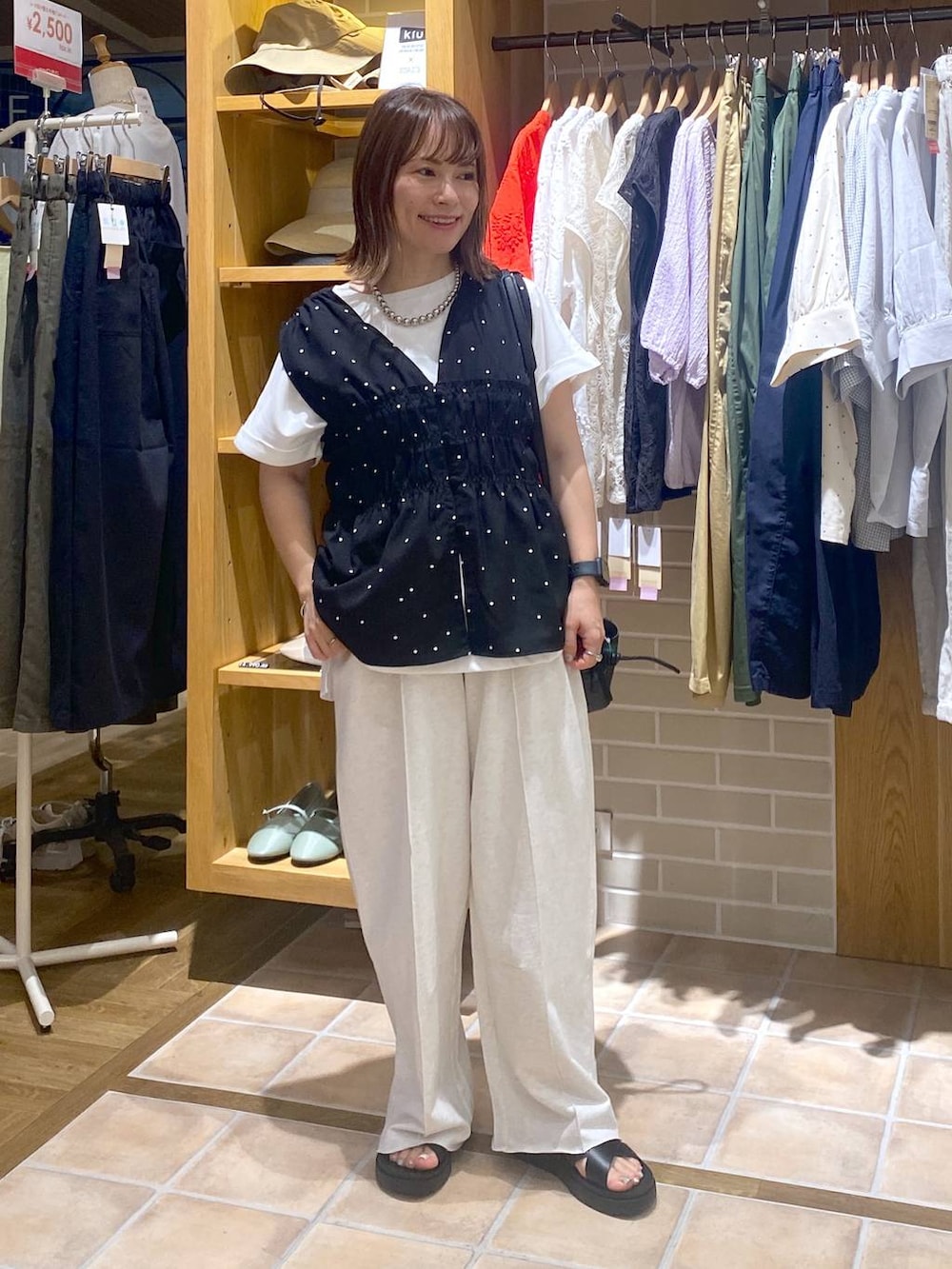 ブラック系のサンダル、ブラック系のその他パンツ、ホワイト系のTシャツ/カットソーを着用したレディースの夏コーディネートの3枚目の写真
