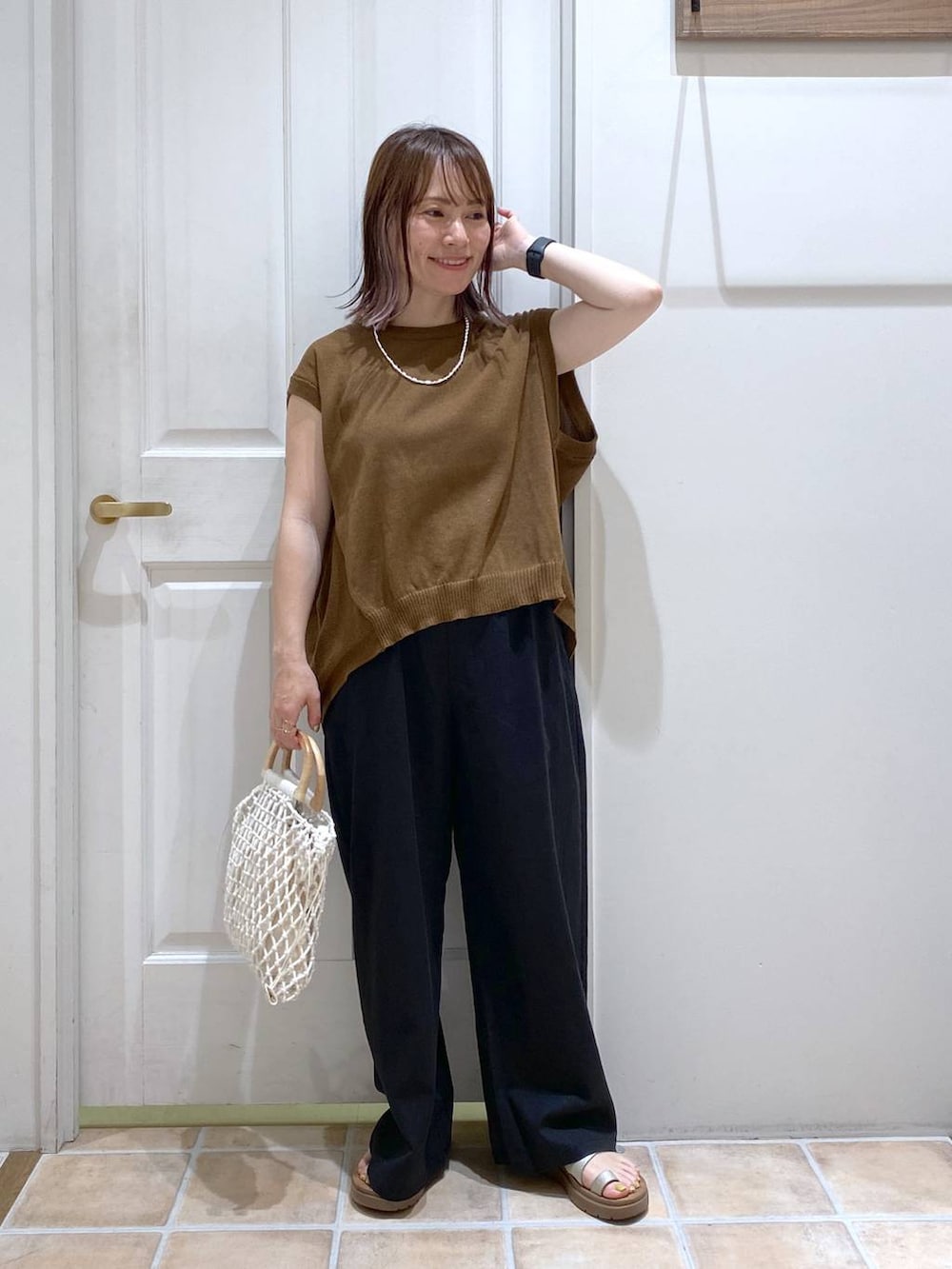 その他のサンダル、ブラック系のその他パンツ、ホワイト系のハンドバッグを着用したレディースの春コーディネートの2枚目の写真