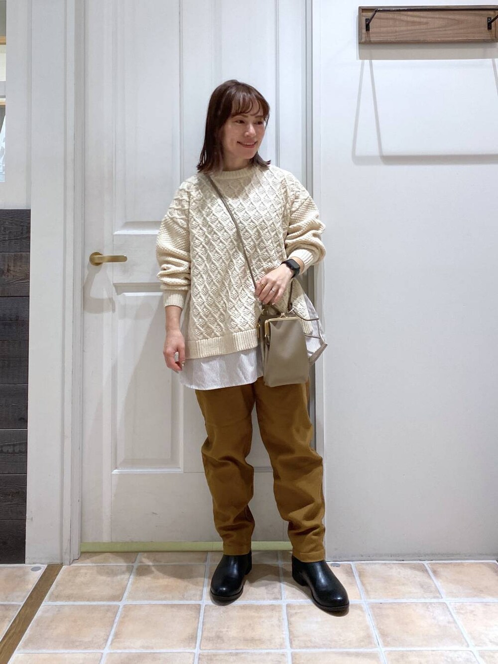 ブラック系のブーツ、イエロー系のその他パンツ、ベージュ系のニット/セーターを着用したレディースの冬コーディネートの2枚目の写真