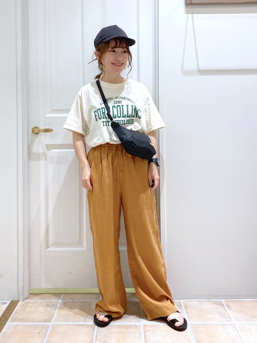 ベージュ系のTシャツ/カットソー、イエロー系のその他パンツ、ブラック系のショルダーバッグを着用したレディースの春コーディネートの2枚目の写真
