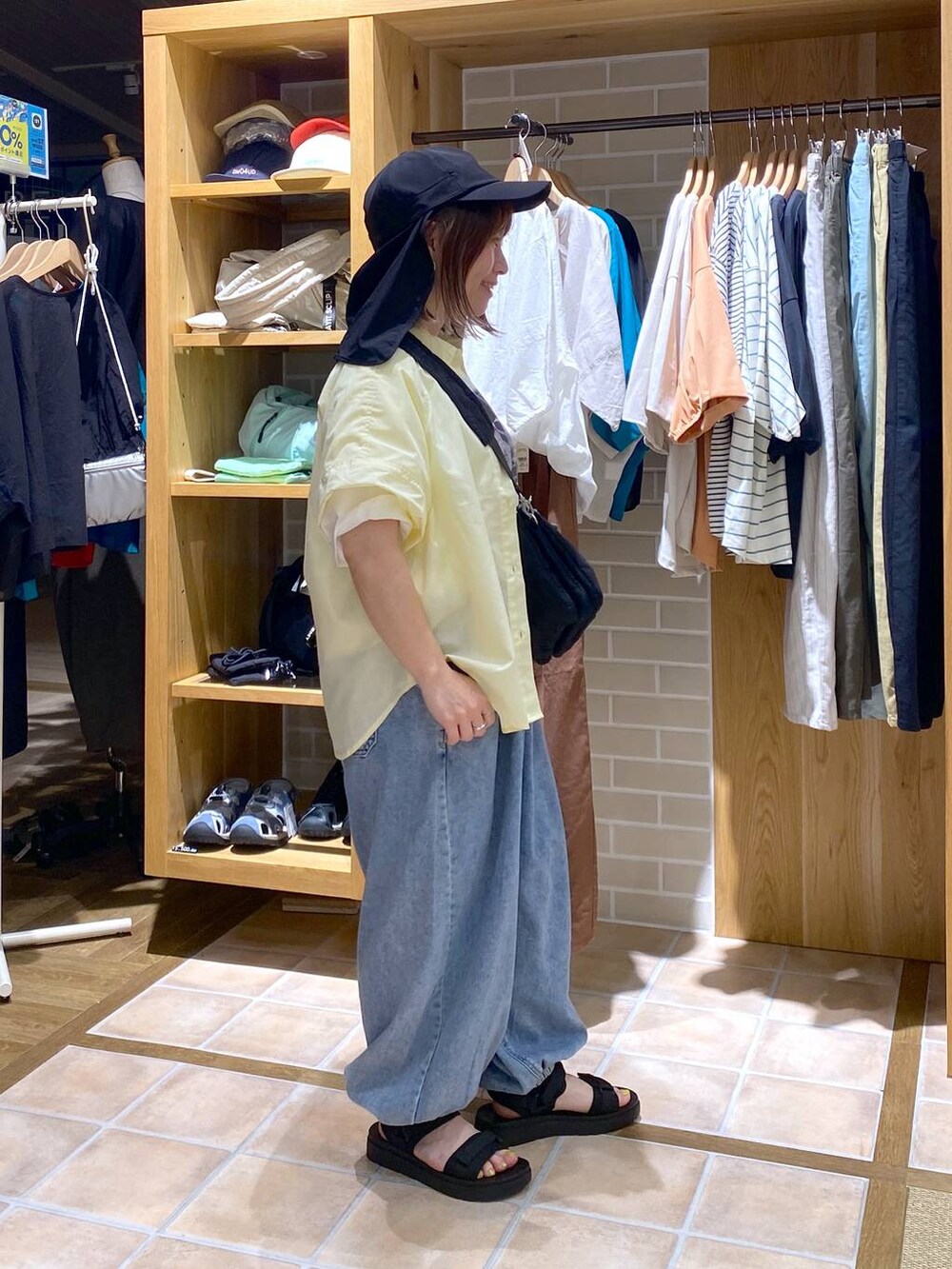 イエロー系のシャツ/ブラウス、ブラック系のサンダル、その他のTシャツ/カットソーを着用したレディースの春コーディネートの4枚目の写真