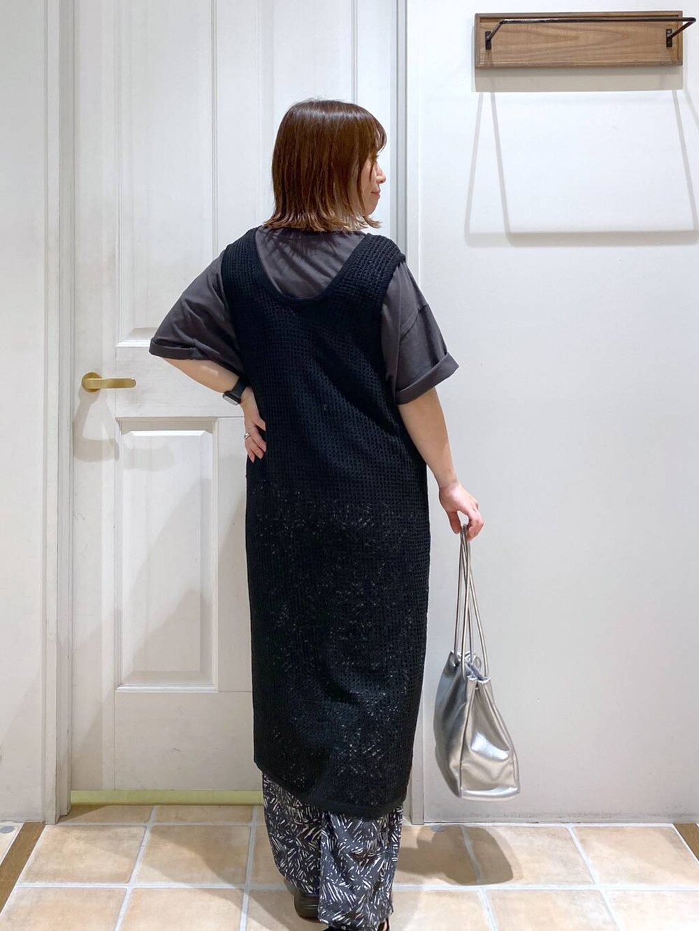 ブラック系のサンダル、ホワイト系のタンクトップ、その他のトートバッグを着用したレディースの夏コーディネートの5枚目の写真