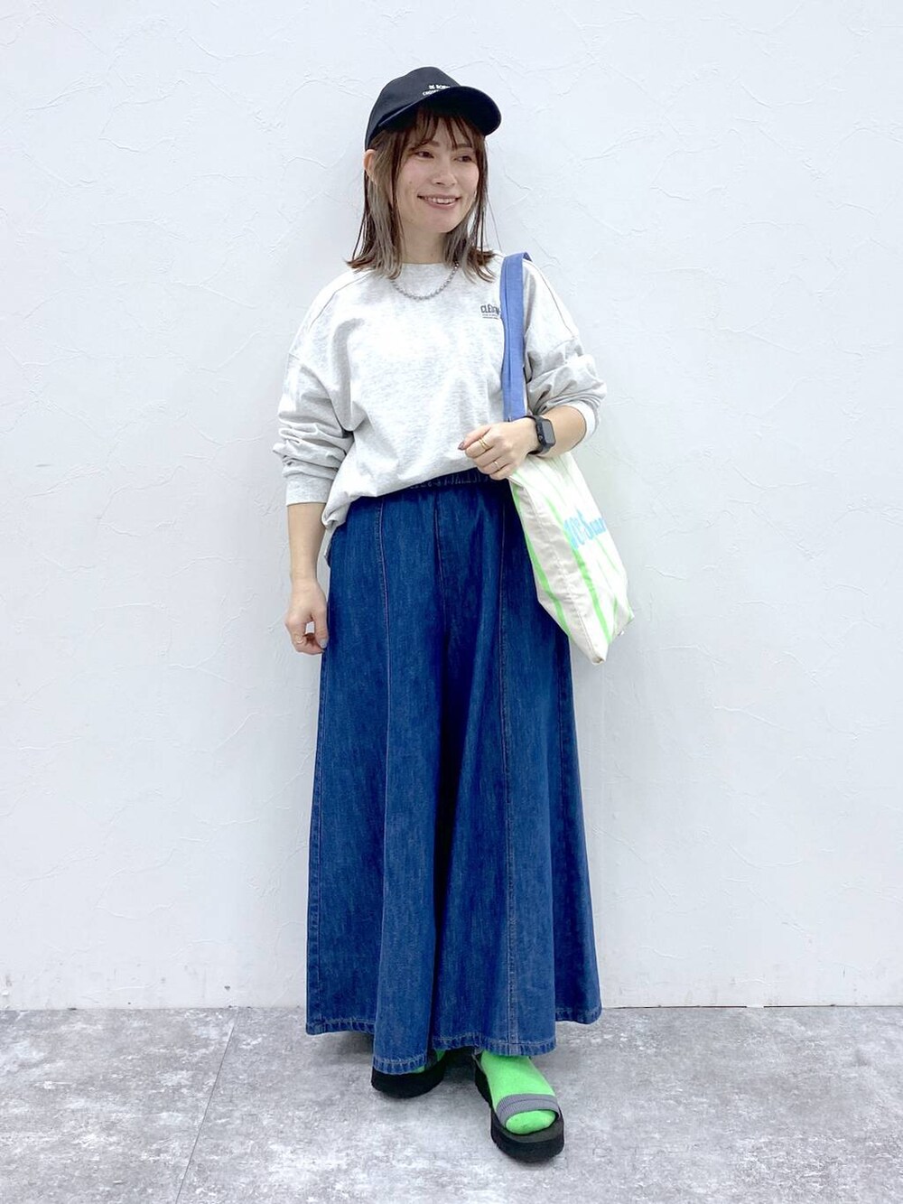 ブルー系のデニムパンツ、その他のトートバッグ、シルバー系のネックレスを着用したレディースの冬コーディネートの2枚目の写真