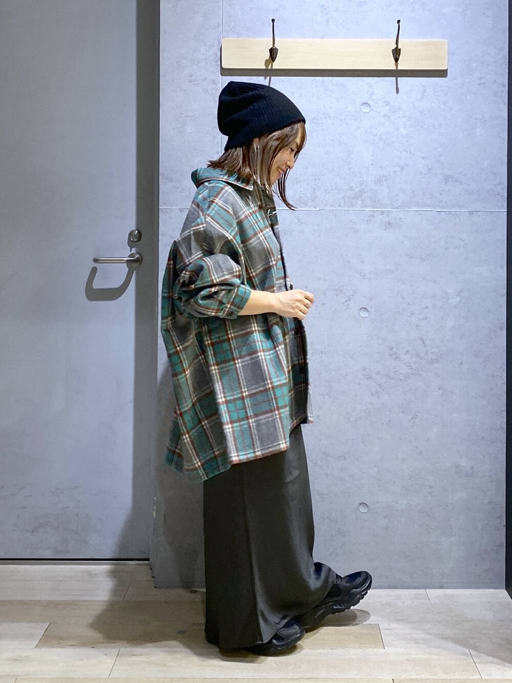 グレー系のスカート、ブラック系のスニーカー、グレー系のシャツ/ブラウスを着用したレディースの秋コーディネートの4枚目の写真