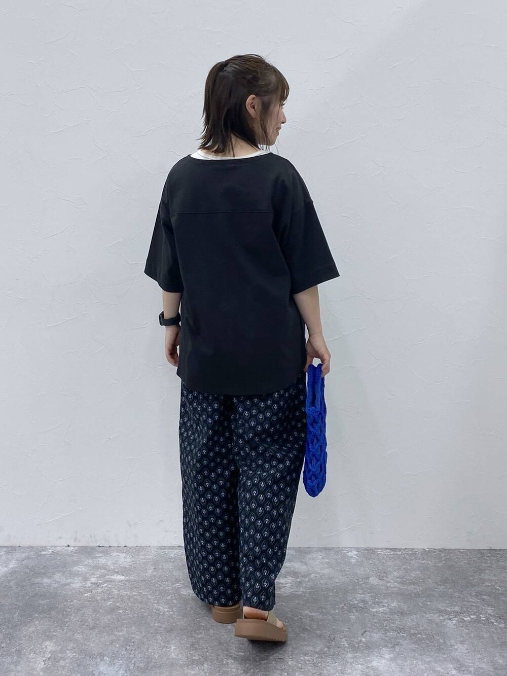 ゴールド系のサンダル、ブラック系のその他パンツ、ブラック系のTシャツ/カットソーを着用したレディースの夏コーディネートの6枚目の写真