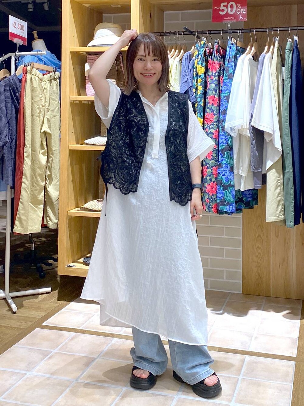 ブラック系のTシャツ/カットソー、ブラック系のサンダル、ブルー系のデニムパンツを着用したレディースの夏コーディネートの3枚目の写真