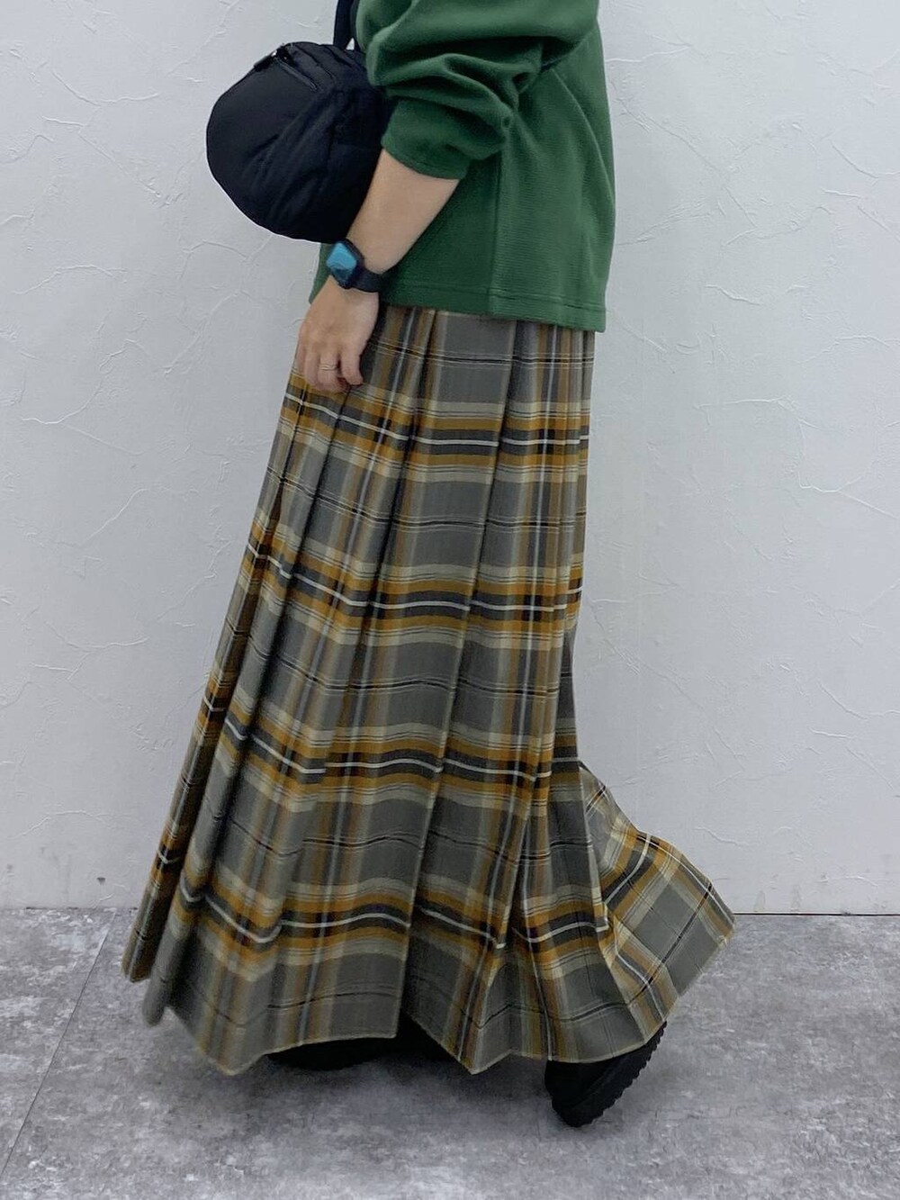 ブラック系のブーツ、ブラック系のショルダーバッグ、その他のスカートを着用したレディースの秋コーディネートの7枚目の写真