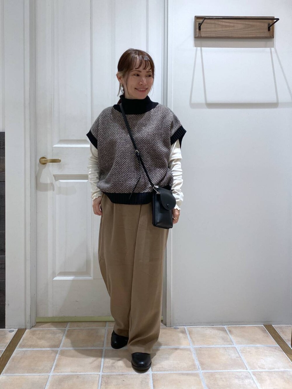 ホワイト系のTシャツ/カットソー、ブラック系のブーツ、ブラック系のベストを着用したレディースの冬コーディネートの3枚目の写真