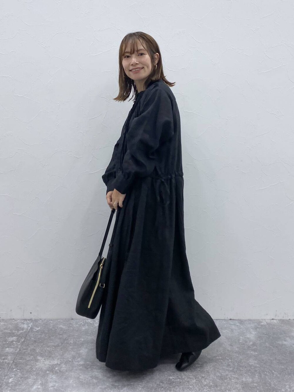 ブラック系のブーツ、ブラック系のショルダーバッグ、ブラック系のワンピースを着用したレディースの夏コーディネートの4枚目の写真