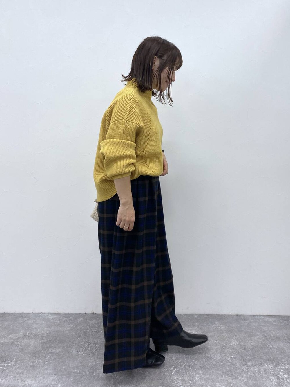 ブラック系のブーツ、イエロー系のニット/セーター、ベージュ系のトートバッグを着用したレディースの秋コーディネートの5枚目の写真