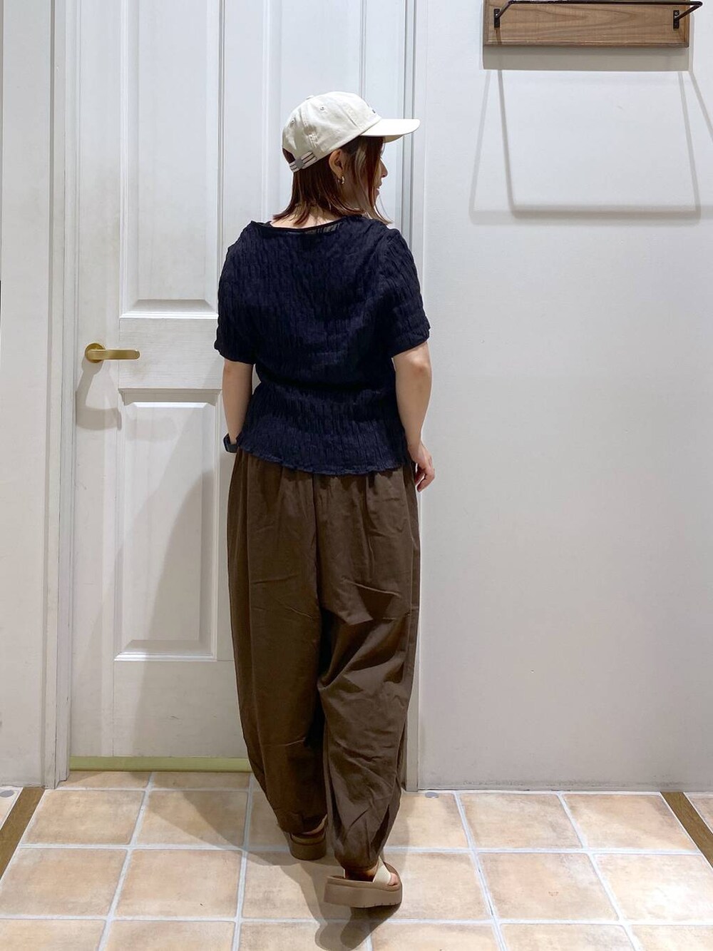 ベージュ系のサンダル、ブラウン系のその他パンツ、ブラック系のシャツ/ブラウスを着用したレディースの夏コーディネートの5枚目の写真