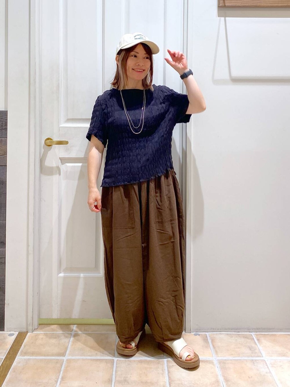 ベージュ系のサンダル、ブラウン系のその他パンツ、ブラック系のシャツ/ブラウスを着用したレディースの夏コーディネートの2枚目の写真