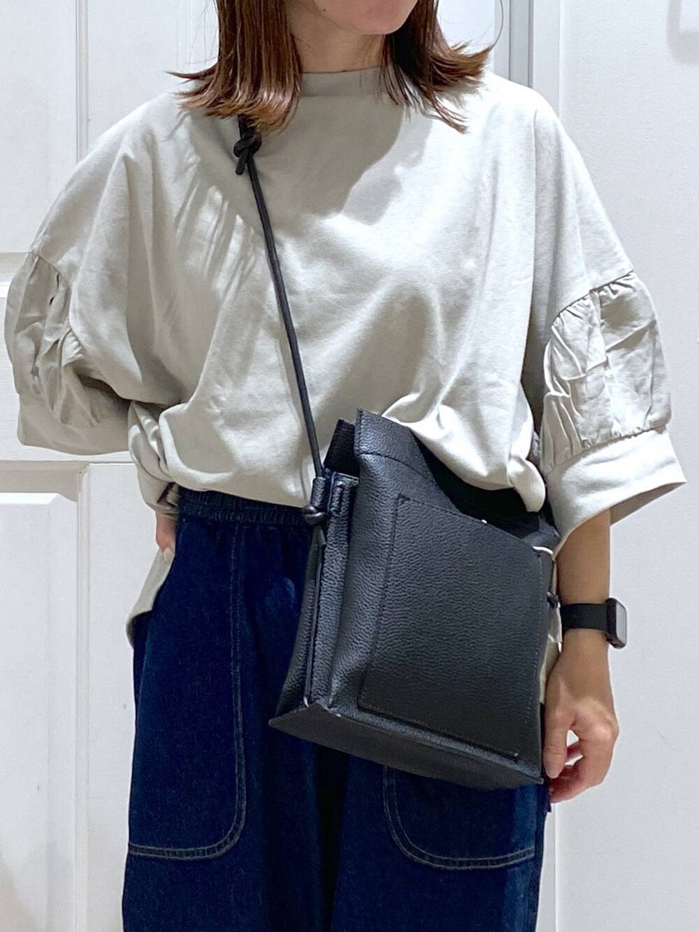 ベージュ系のタンクトップ、ブルー系のデニムパンツ、グリーン系のTシャツ/カットソーを着用したレディースの夏コーディネートの3枚目の写真