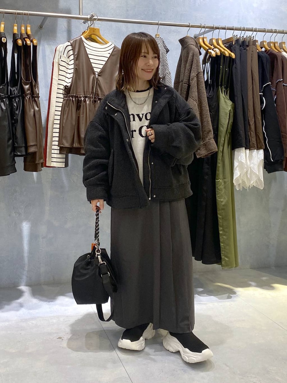 ブラック系のショルダーバッグ、ブラック系のニット/セーター、ホワイト系のニット/セーターを着用したレディースの秋コーディネートの3枚目の写真