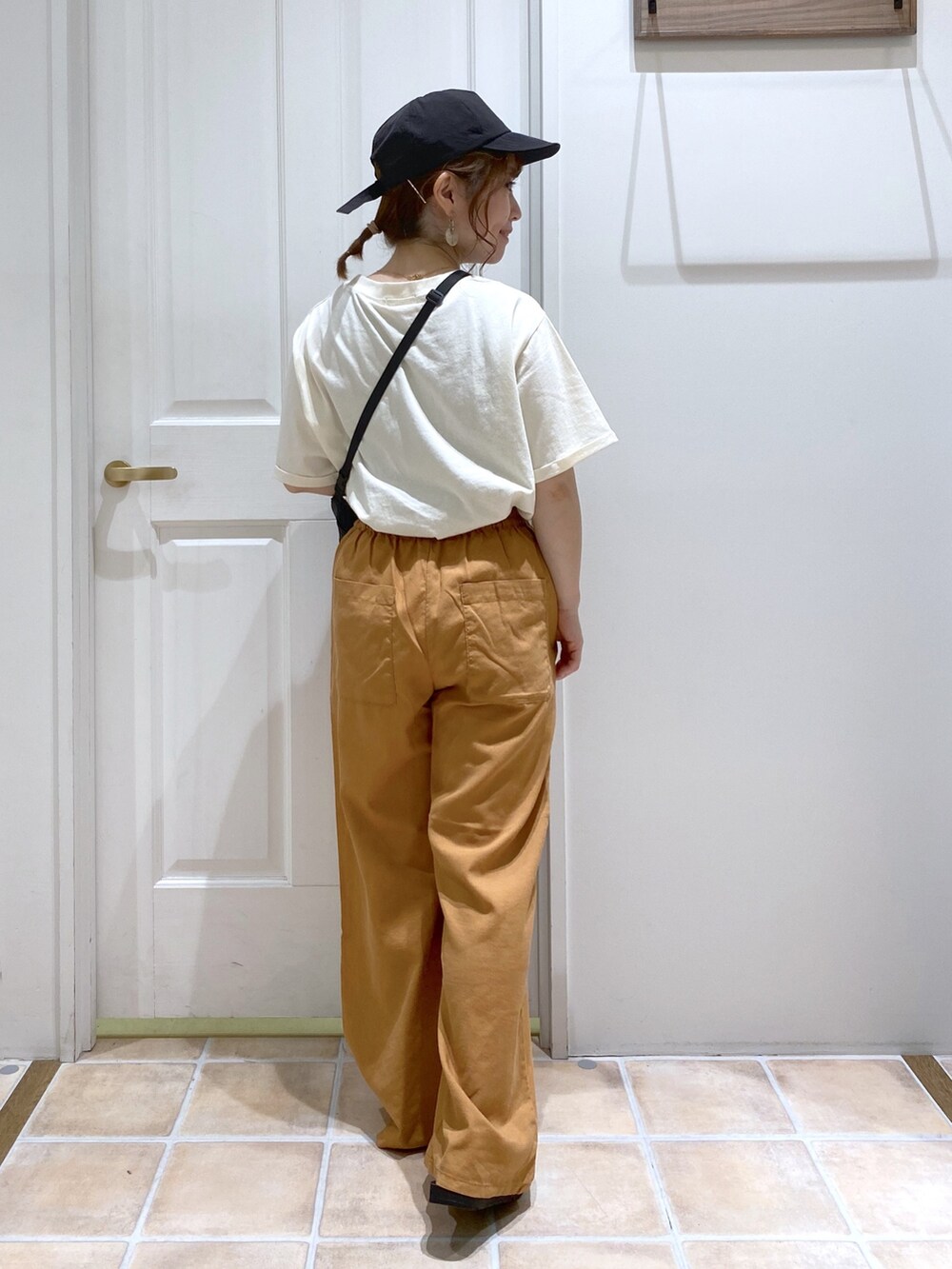 ベージュ系のTシャツ/カットソー、イエロー系のその他パンツ、ブラック系のショルダーバッグを着用したレディースの春コーディネートの4枚目の写真